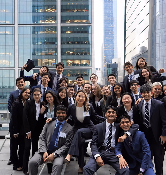 Scholars of Finance students posing together on a rooftop in front of glass office towers