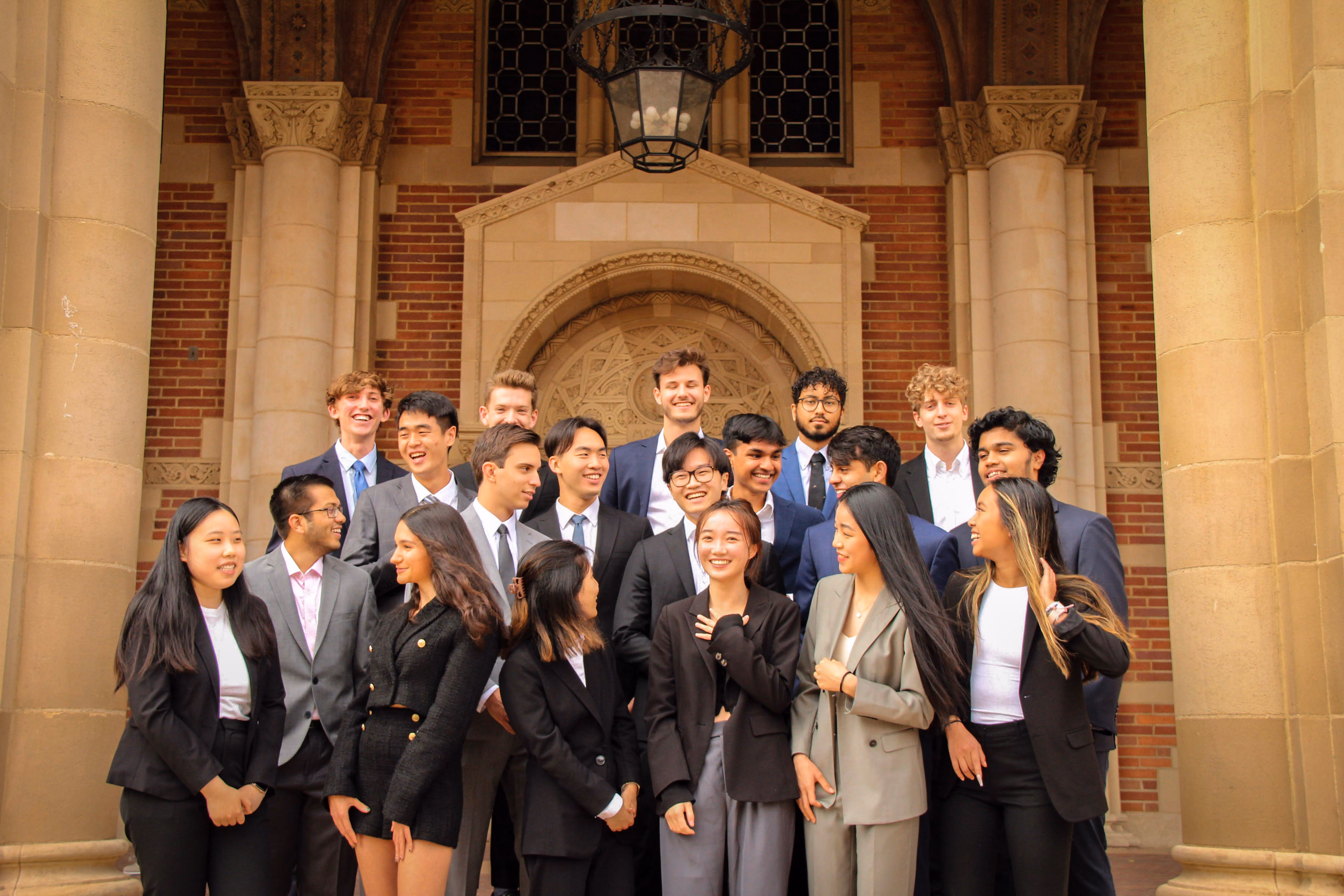 Group photo of the UCLA Scholars of Finance chapter in business attire in front of a brick campus building