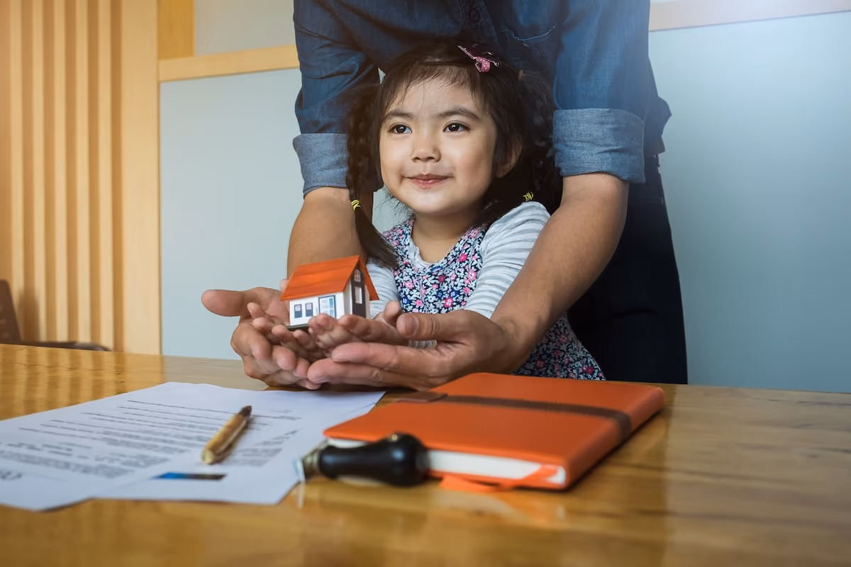young child holding small house