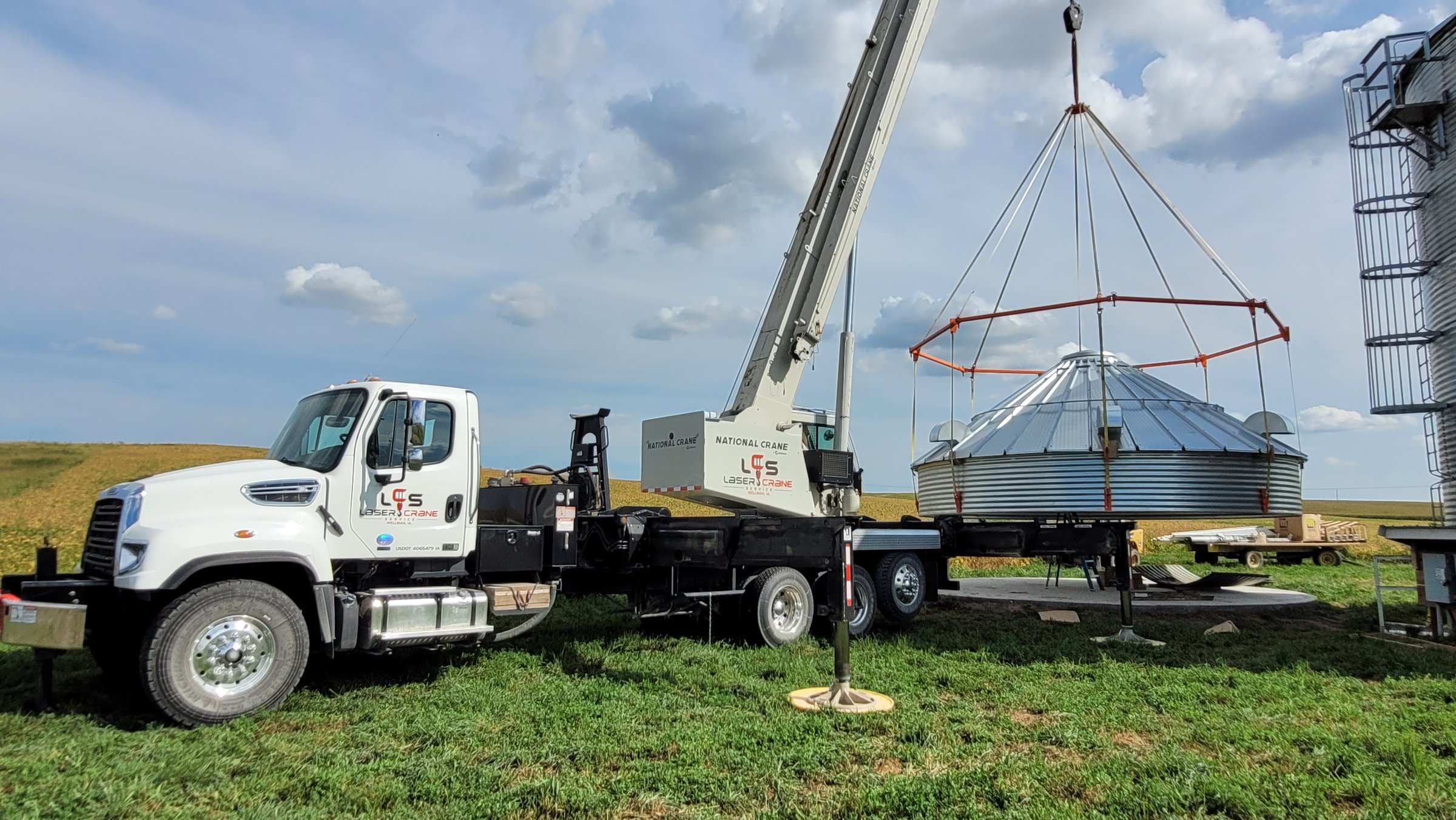 Boom truck setting a grain bin roof in Iowa