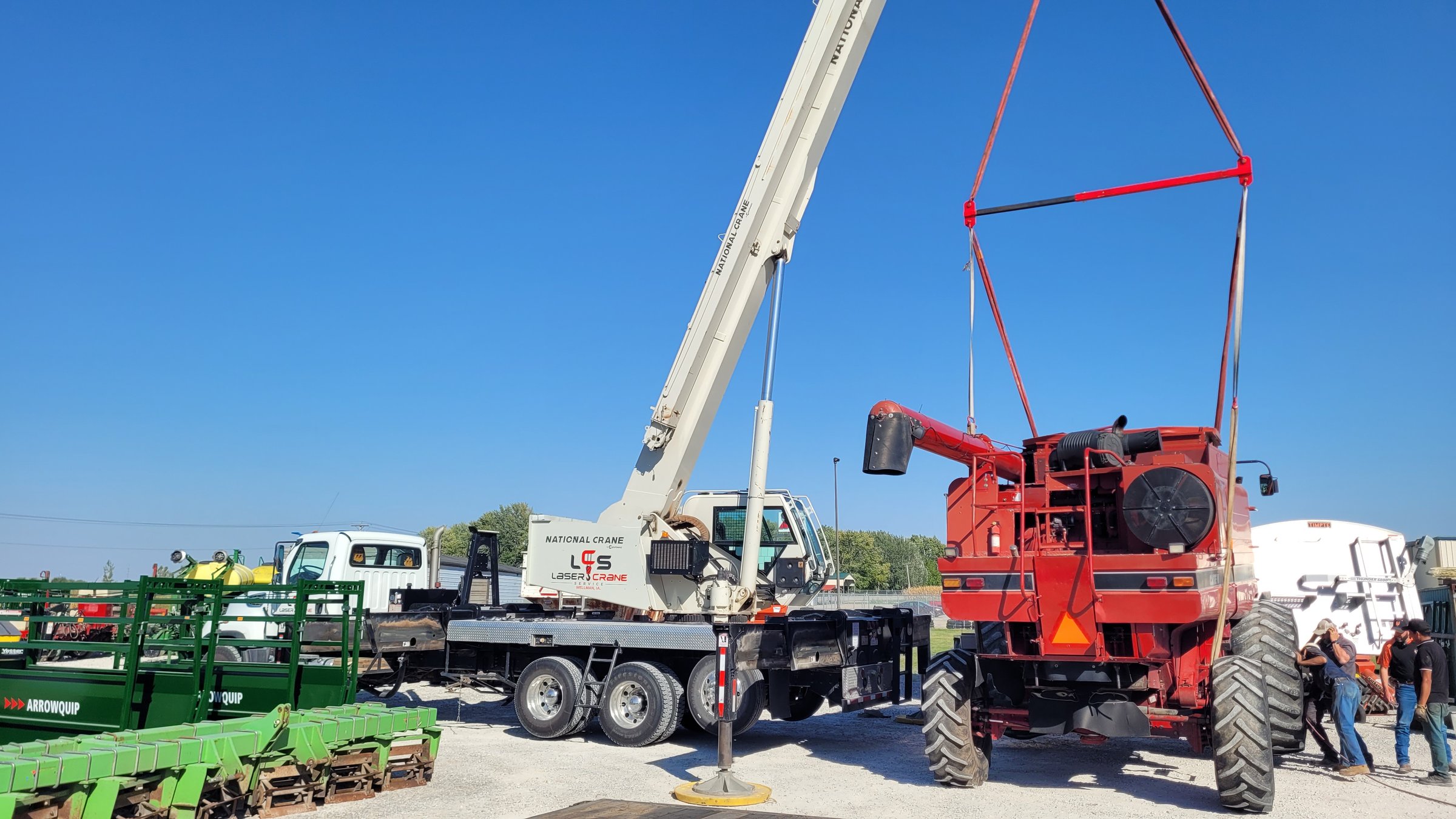 Rigging crew lifting a combine head with a truck crane