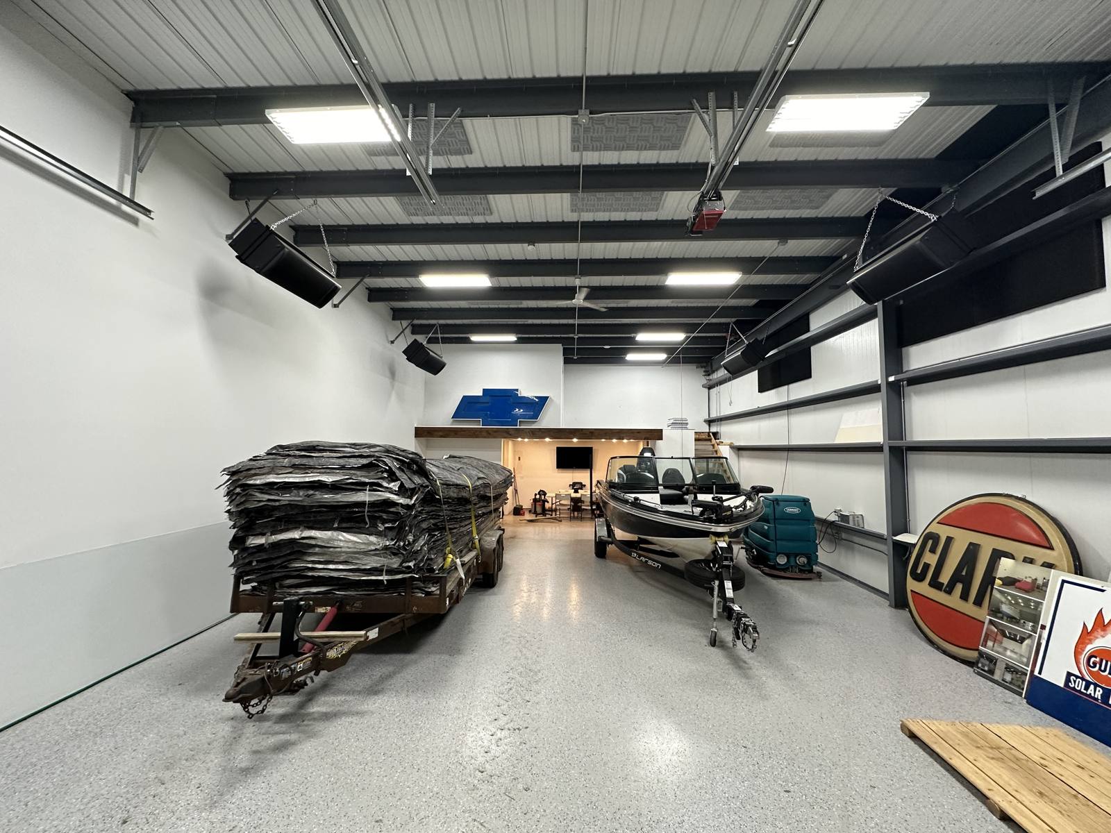 Boat, trailer and vintage signs in a garage with a lounge