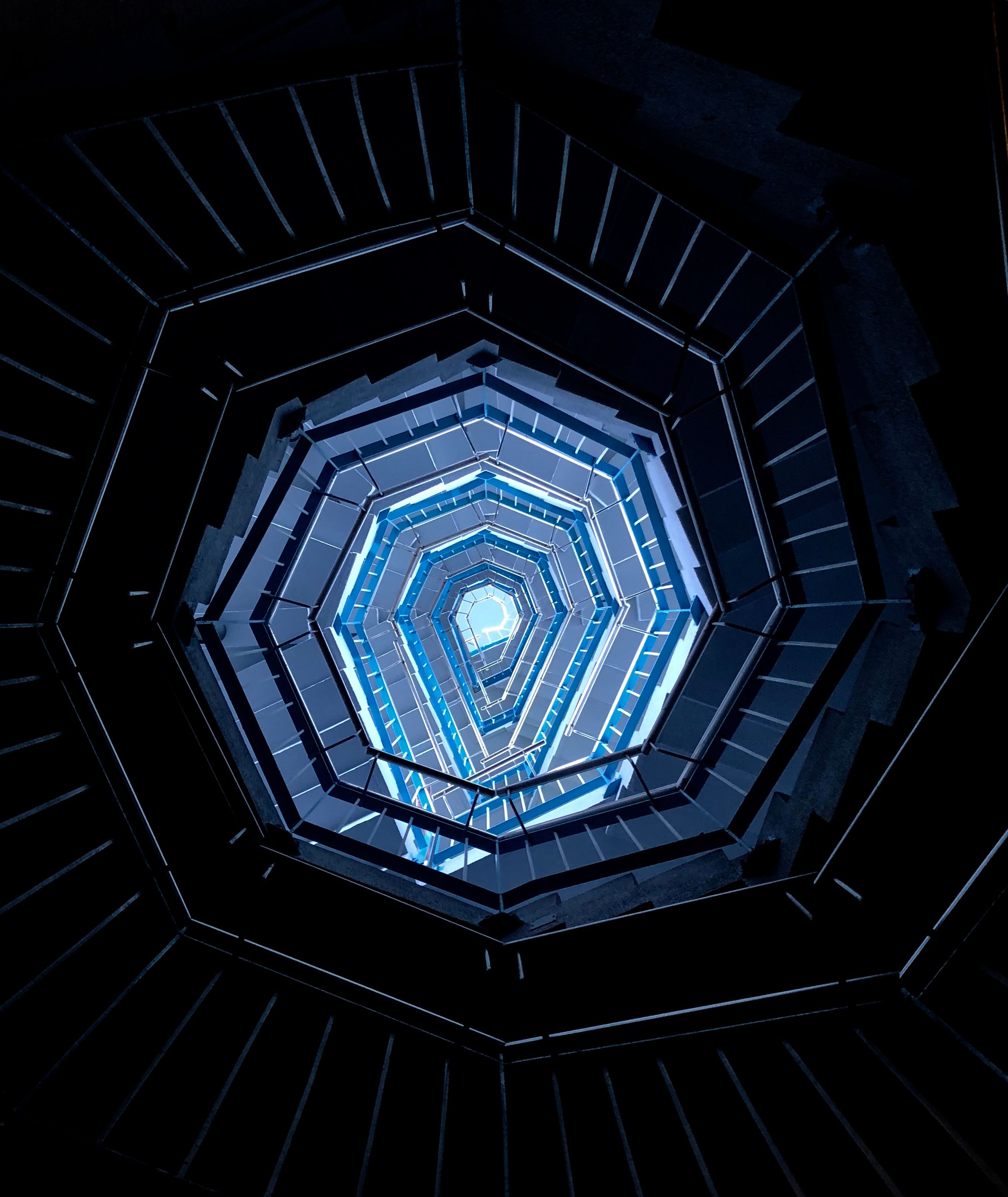 Abstract blue geometric spiral staircase representing architectural depth and scale