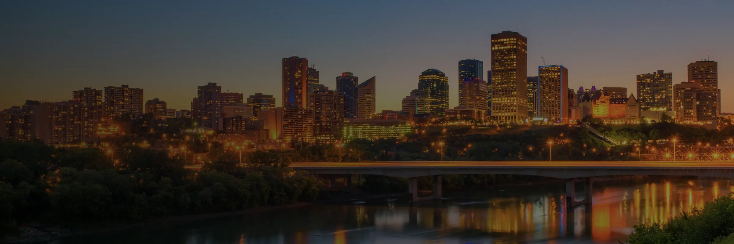 Prairie city skyline lit up at dusk