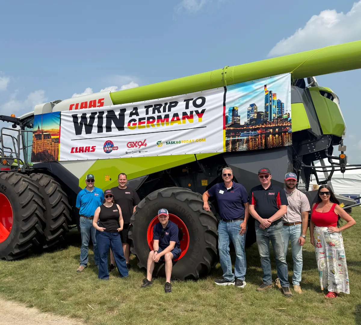 Team standing in front of a sponsored combine at a field day
