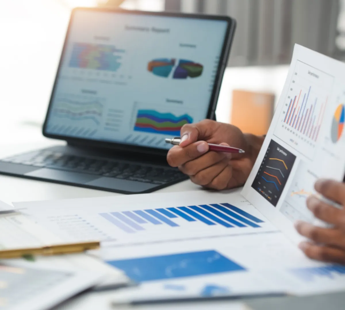 Campaign performance reports on a tablet and paper