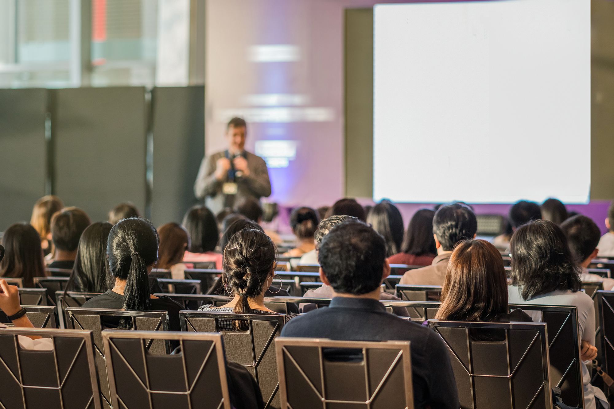 A facilitator addressing a client event audience