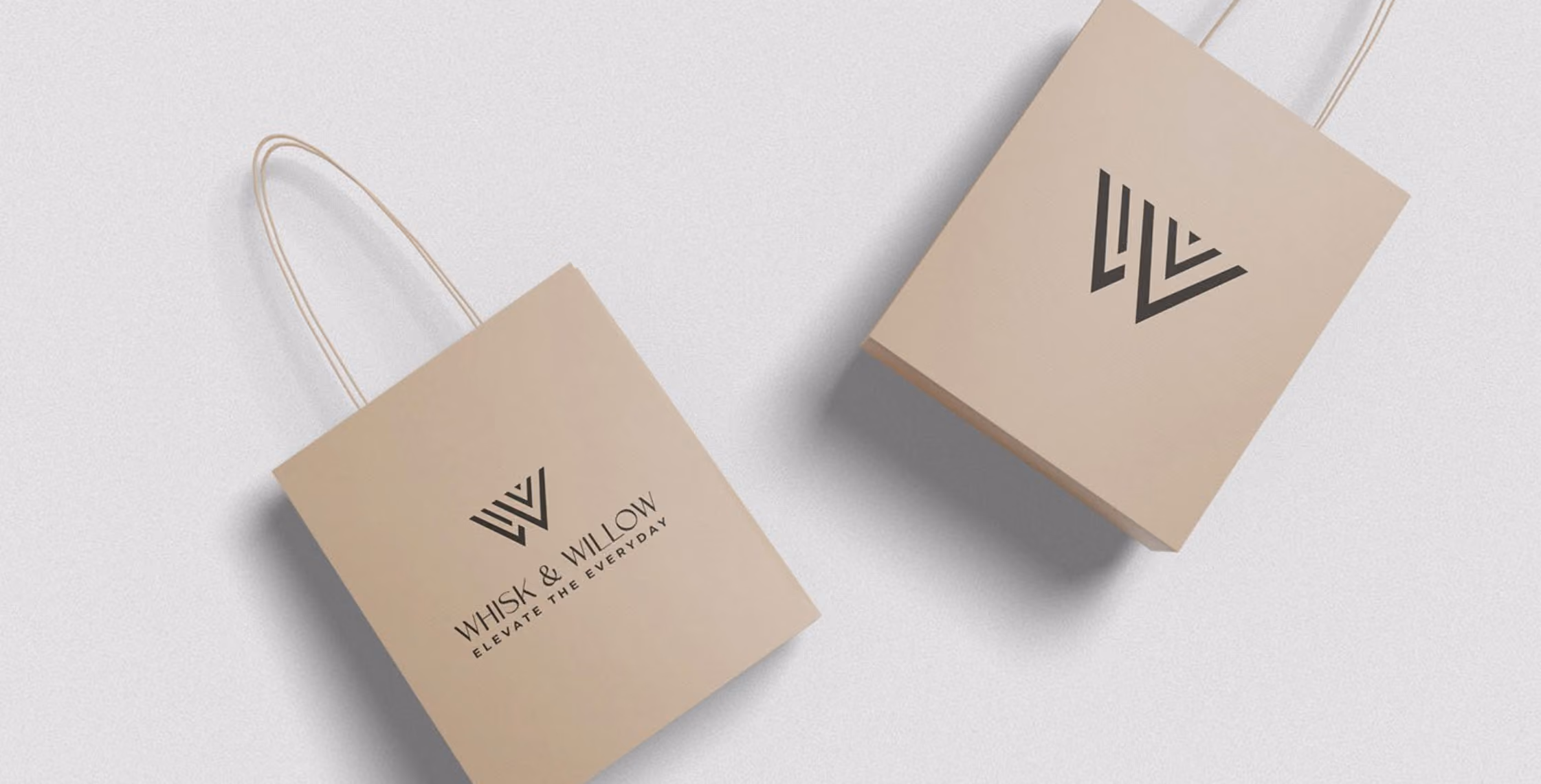 Two beige shopping bags with thin handles, one showing a geometric logo and the other with the text 'WHISK & WILLOW ELEVATE THE EVERYDAY'.