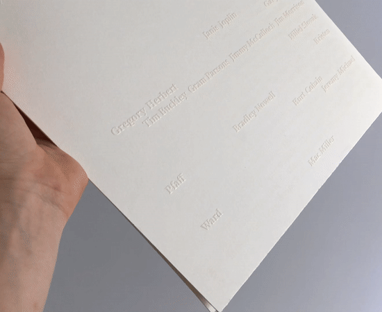 Close-up of the names on the back of a sleeve as the light catches the gloss.