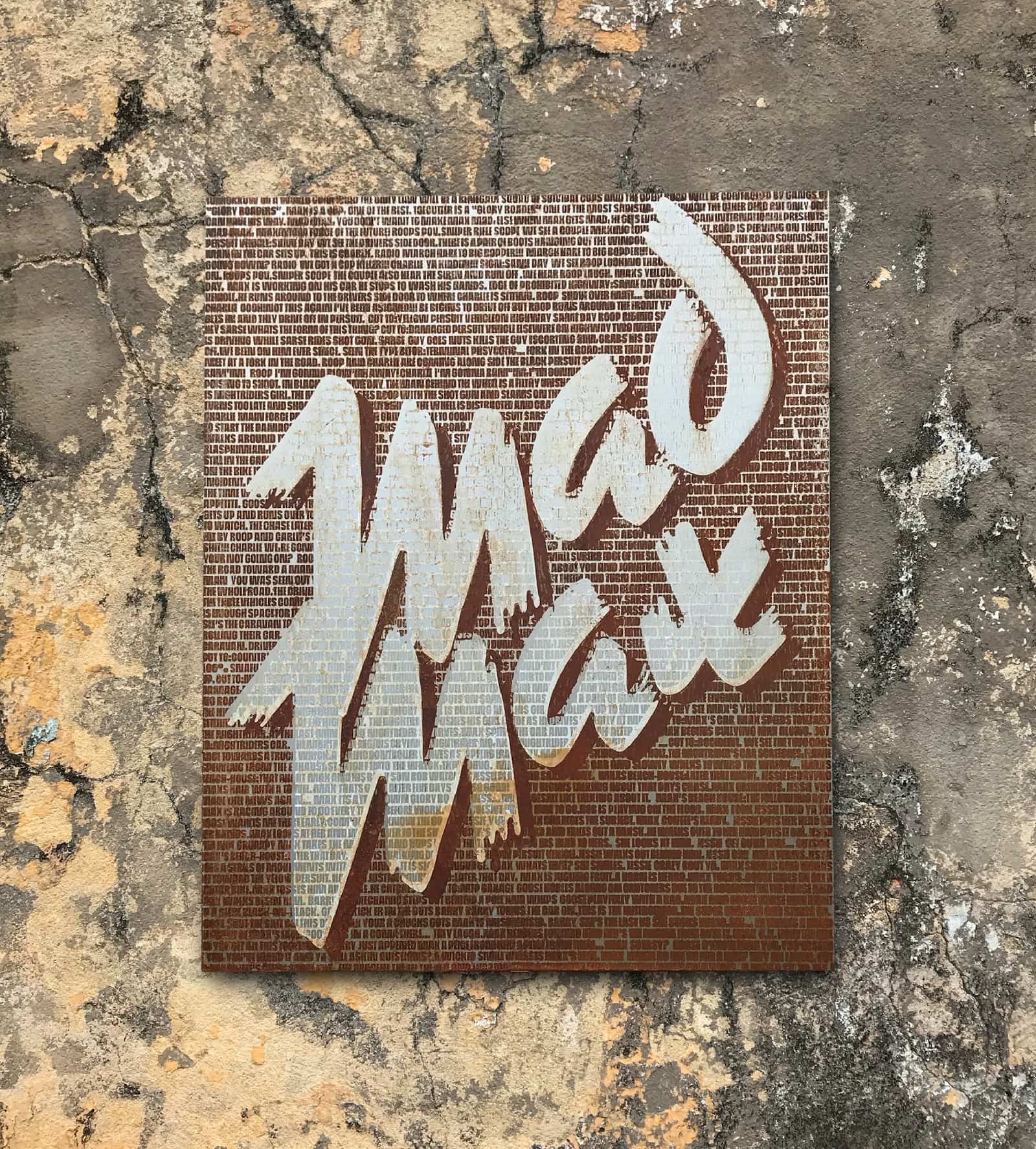 The back of the finished poster: the Mad Max wordmark in white over a field of rust made of the trailer’s narration in small text.