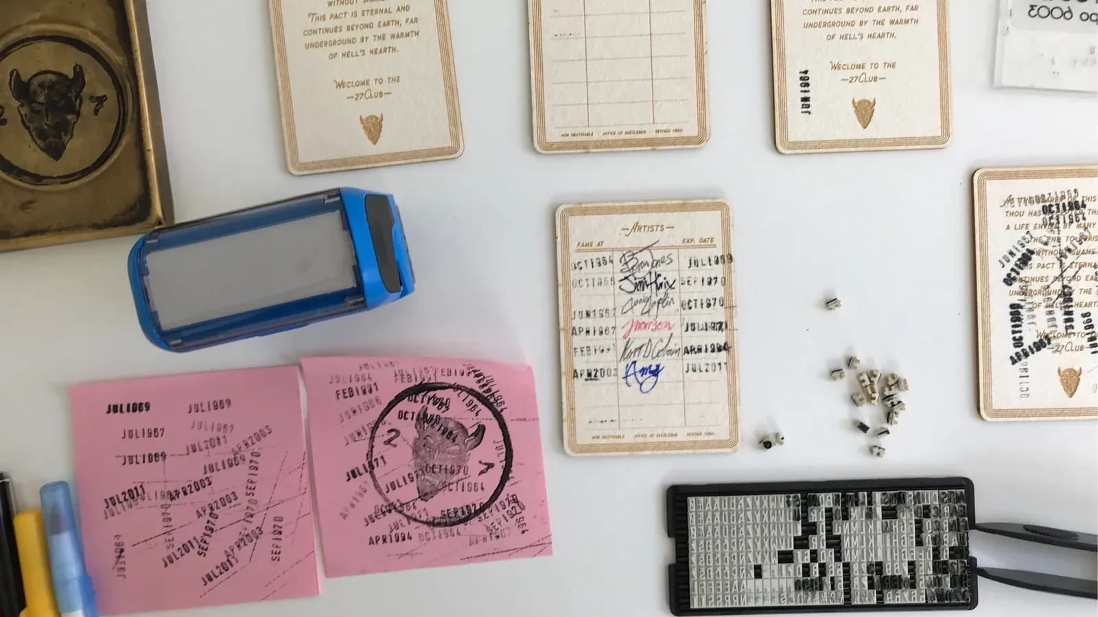 Etched cards, a date stamp, loose type and pink test sheets covered in stamped dates.