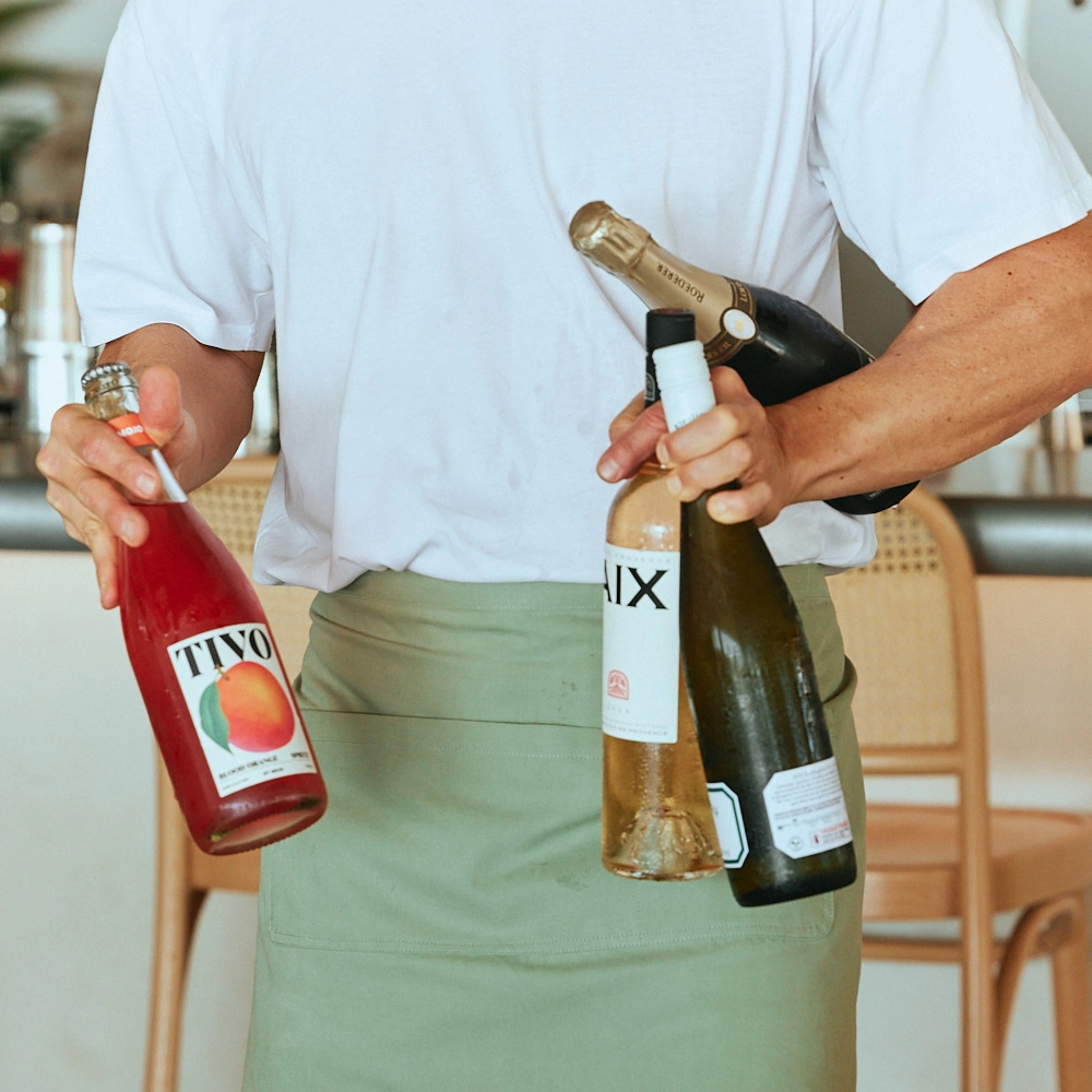 Waiter holding bottles of rosé, white wine and sparkling at The Tropic