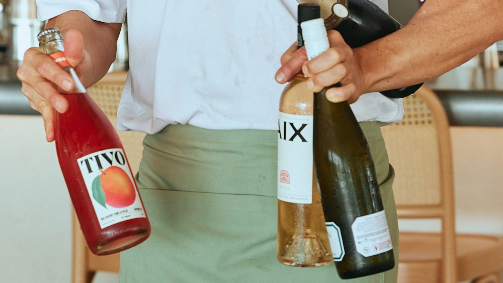 Waiter holding bottles of rosé, white wine and sparkling at The Tropic