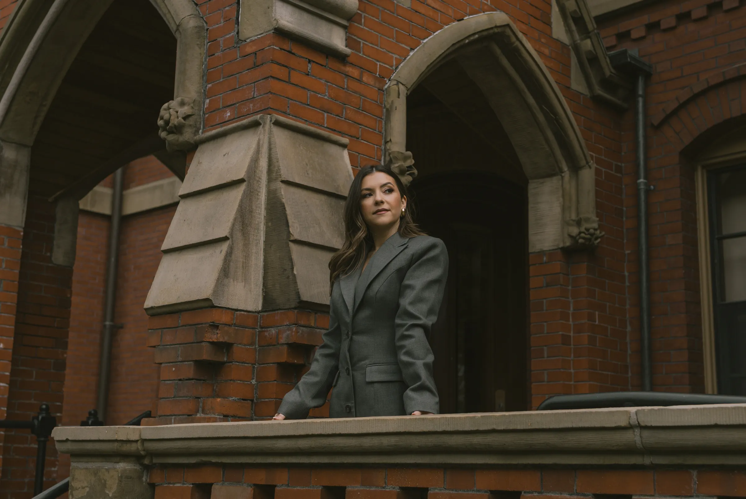 Giulia Guerrieri on a stone balcony in front of a brick building