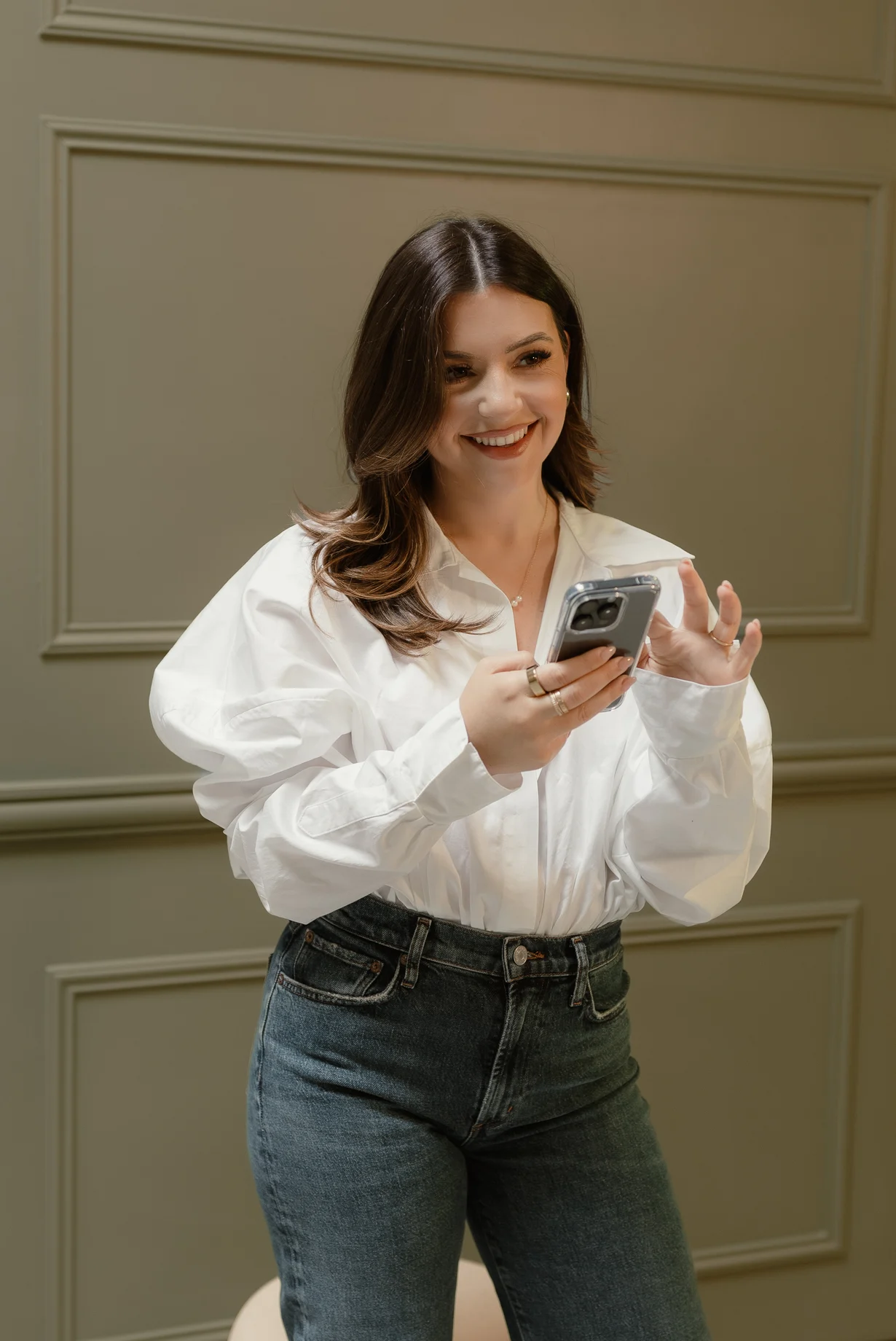 Giulia Guerrieri in a white shirt holding her phone
