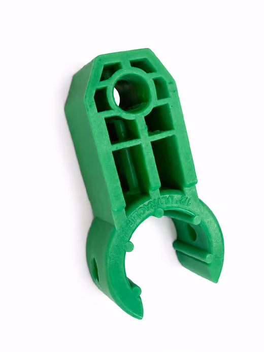Green plastic clip with circular and rectangular cutouts isolated on white background.