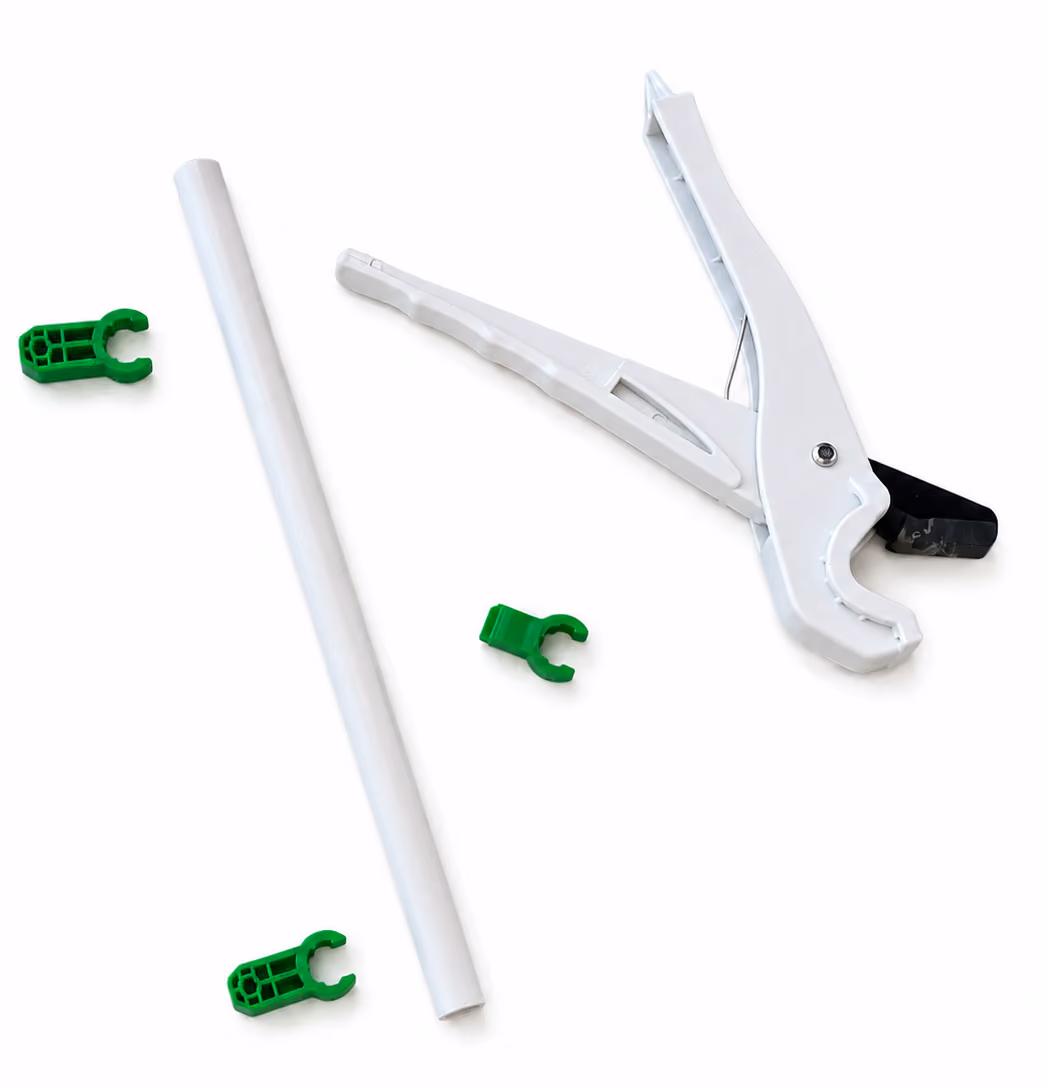 White plastic pipe cutter tool with three green pipe clips and a white pipe on a white background.