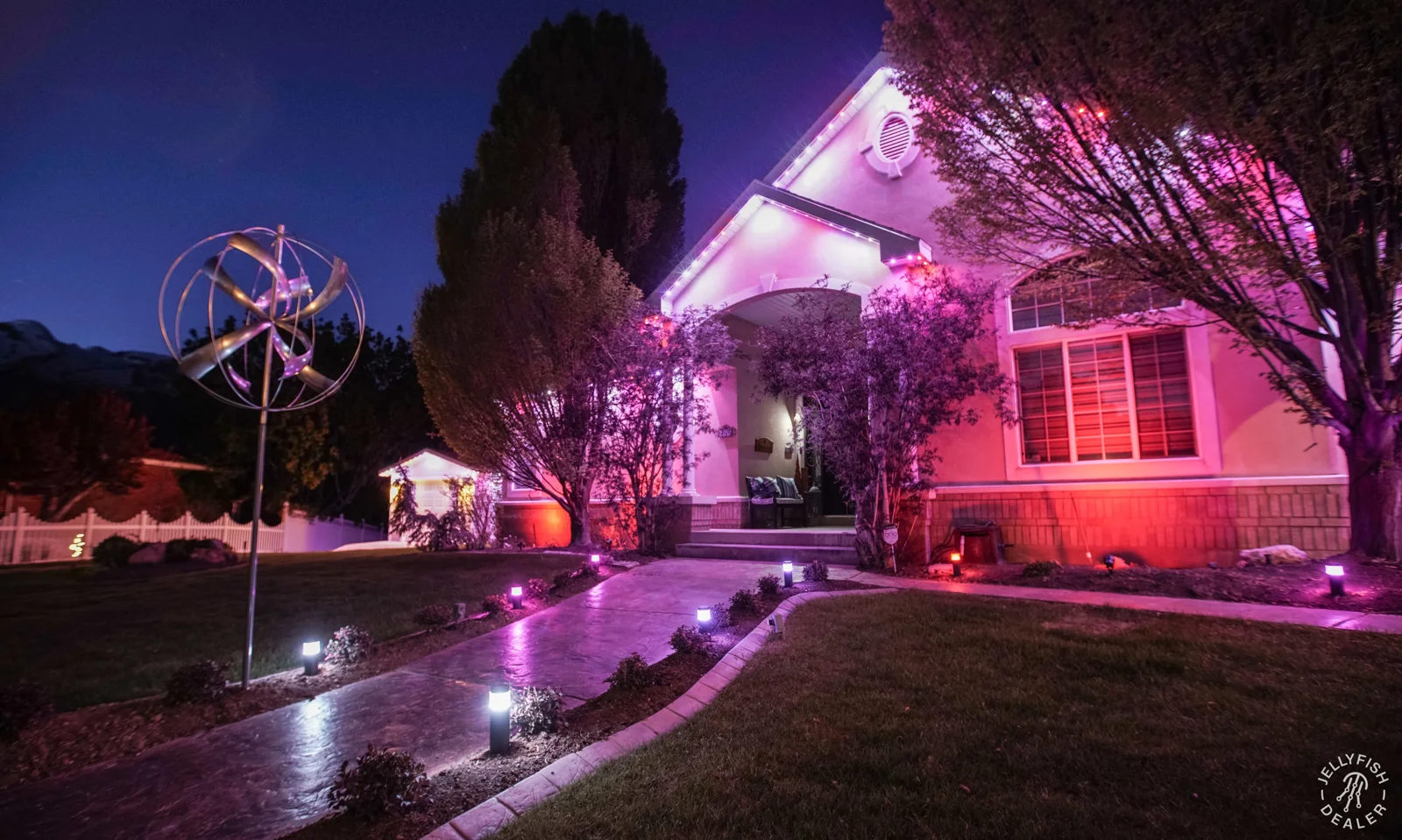 Pink accent lights illuminating a home and landscaping.