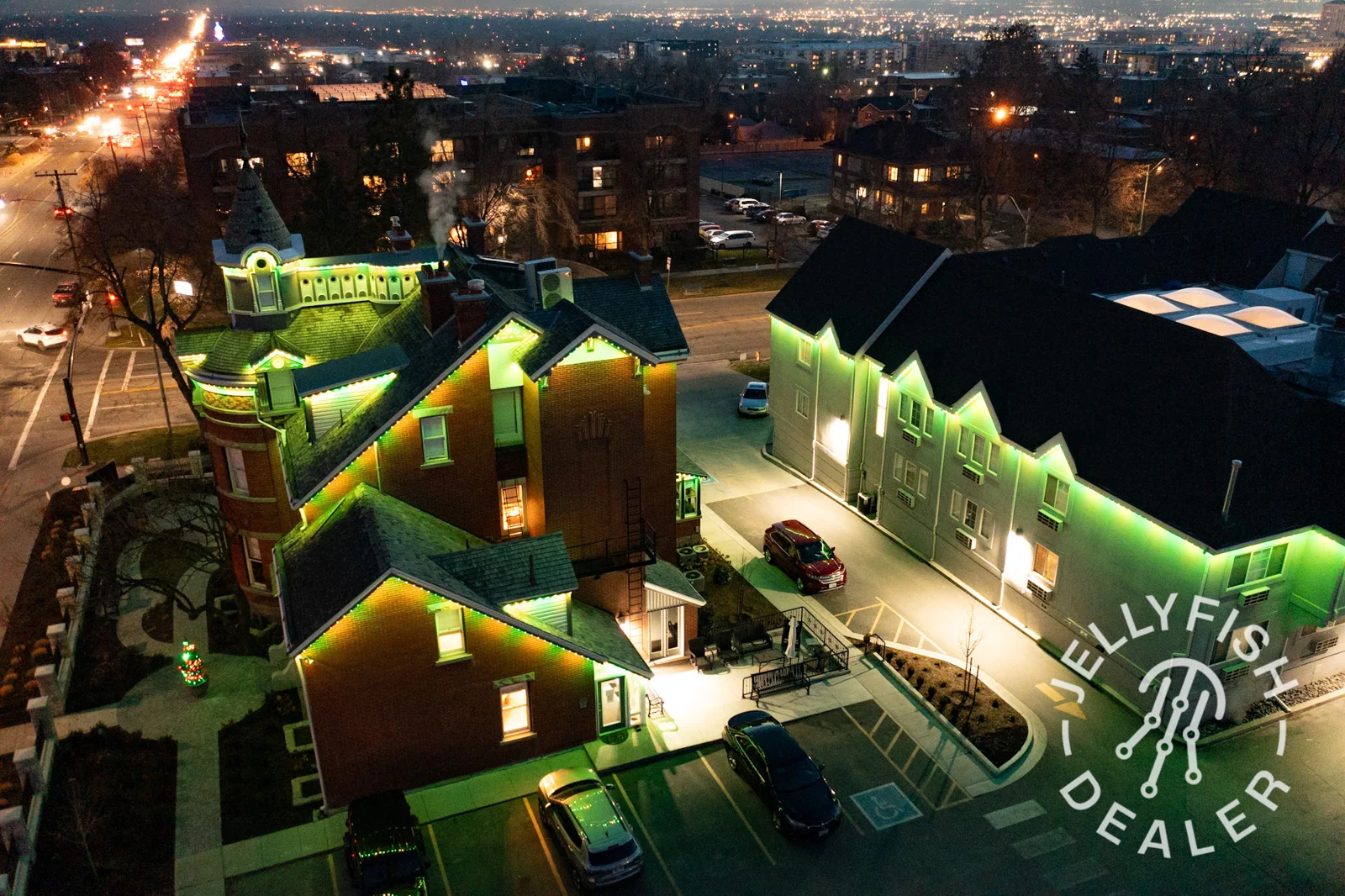 Manufacturer aerial example of green JellyFish roofline lighting at night.