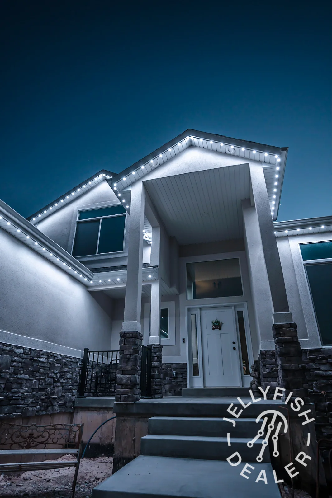 White exterior lights illuminating a roofline and covered entry area.