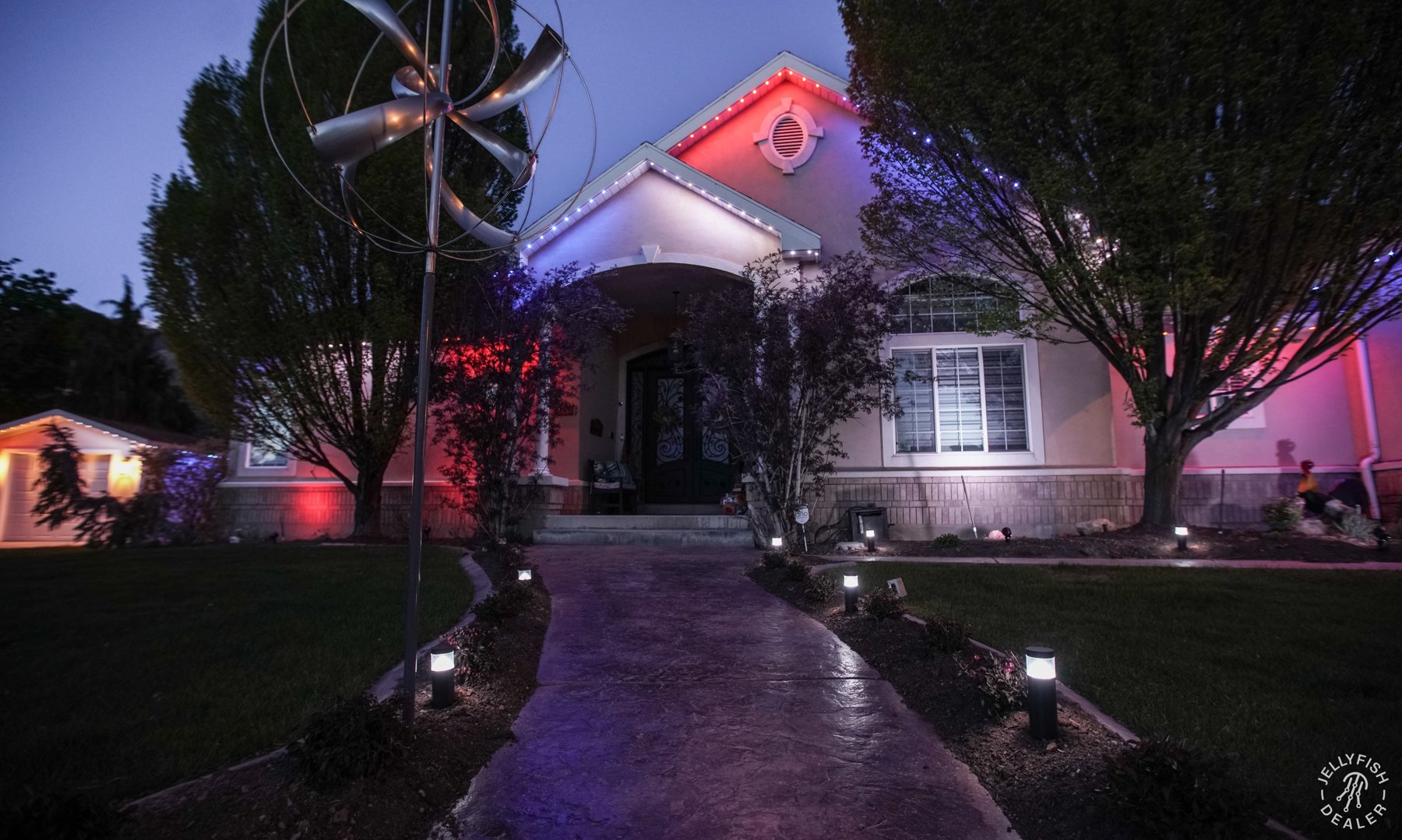 Patriotic lighting around a home and landscaped front approach.