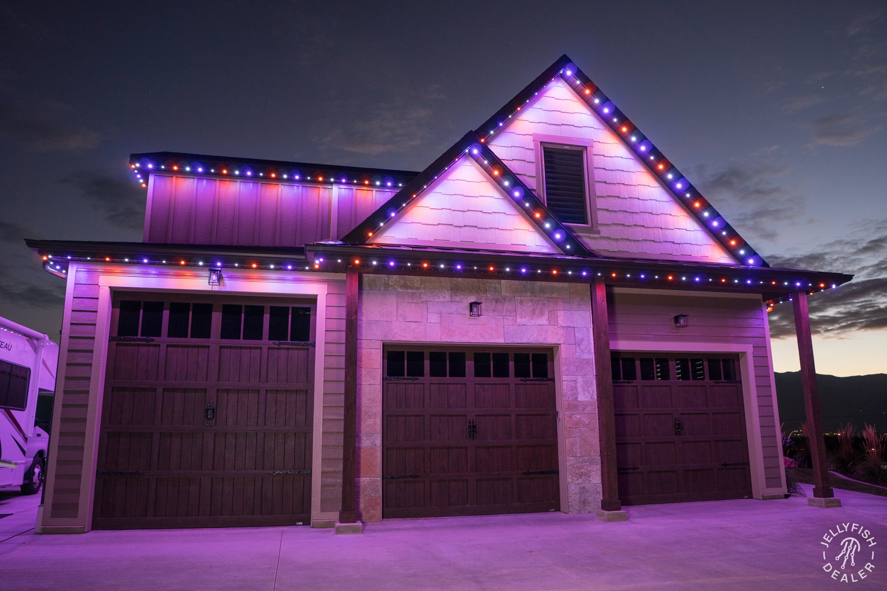 Pink and purple lights outlining a home and garage.