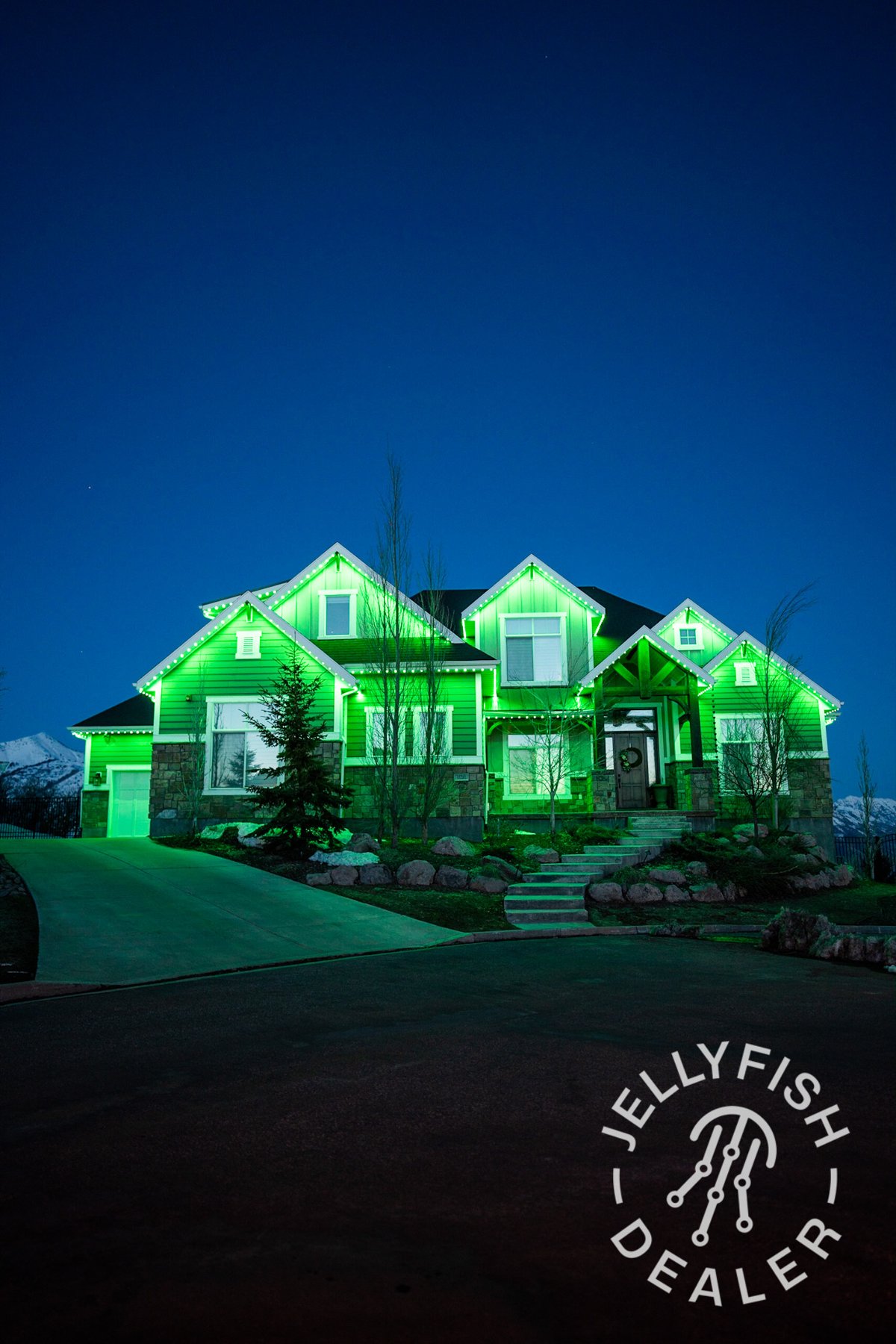 Green lights outlining a large home at night.