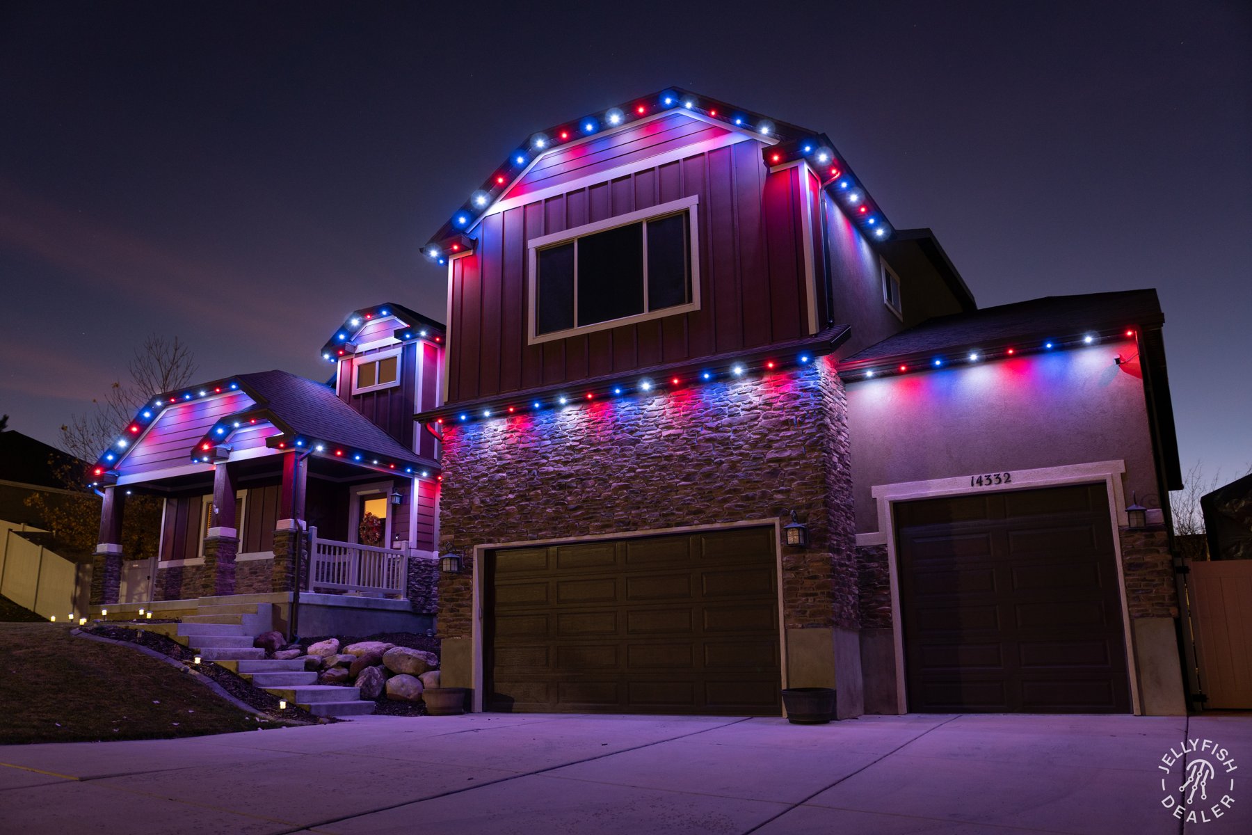 Red, white and blue lights tracing a home and garage.