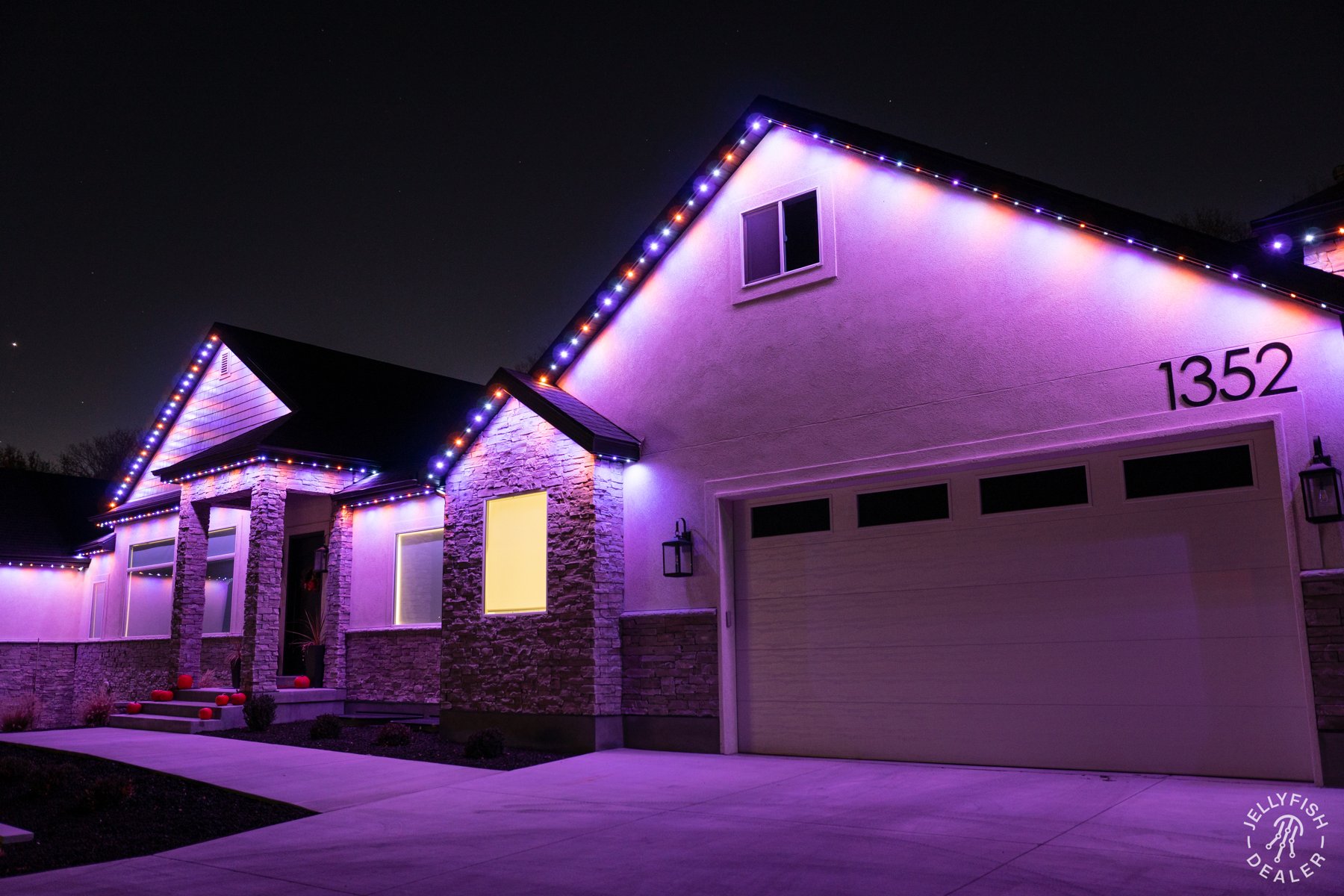 Alternating patriotic lights along a home and attached garage.