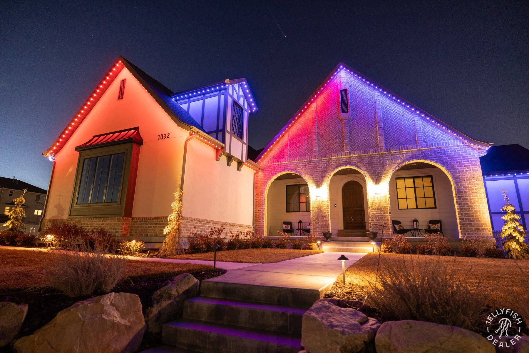 Red, white and blue lighting on a stucco home at dusk.