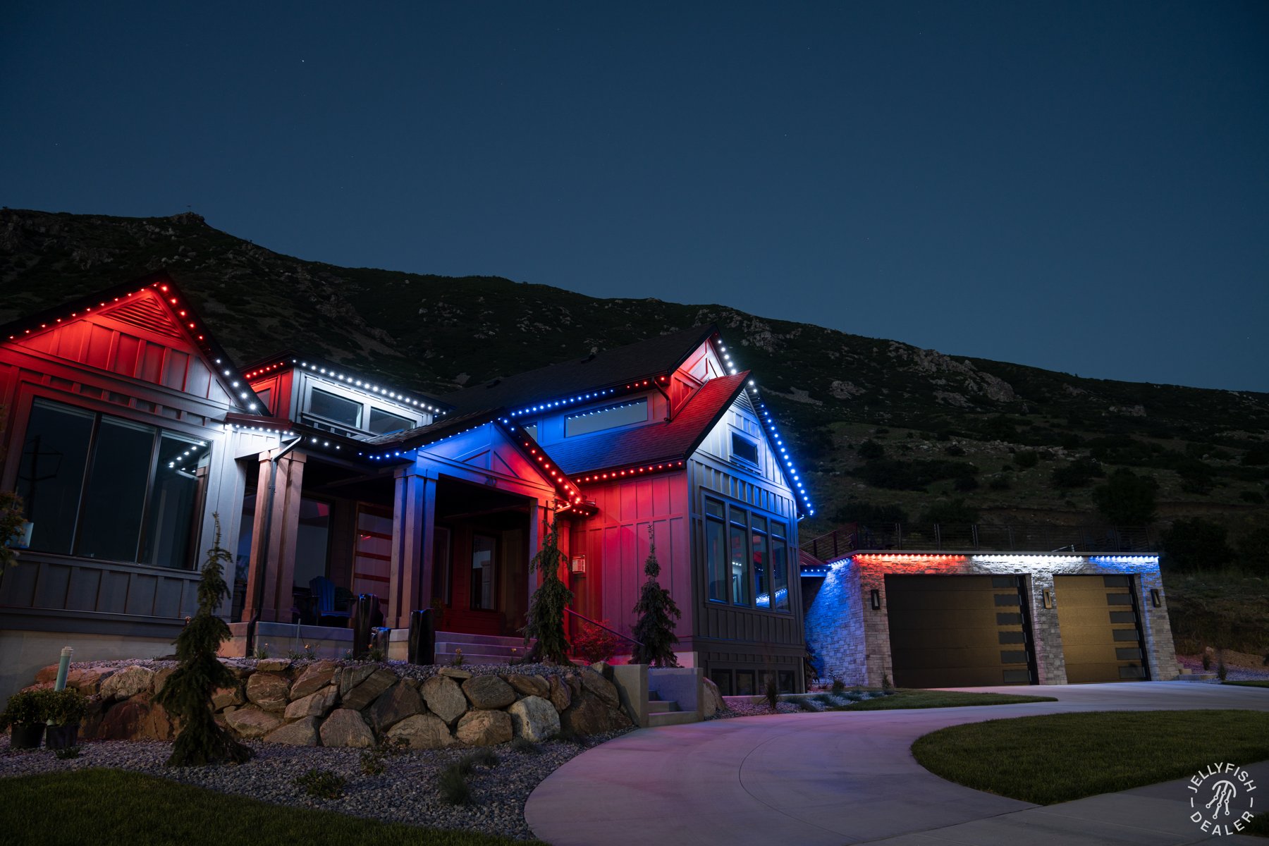 Patriotic lighting across a modern farmhouse and garage.