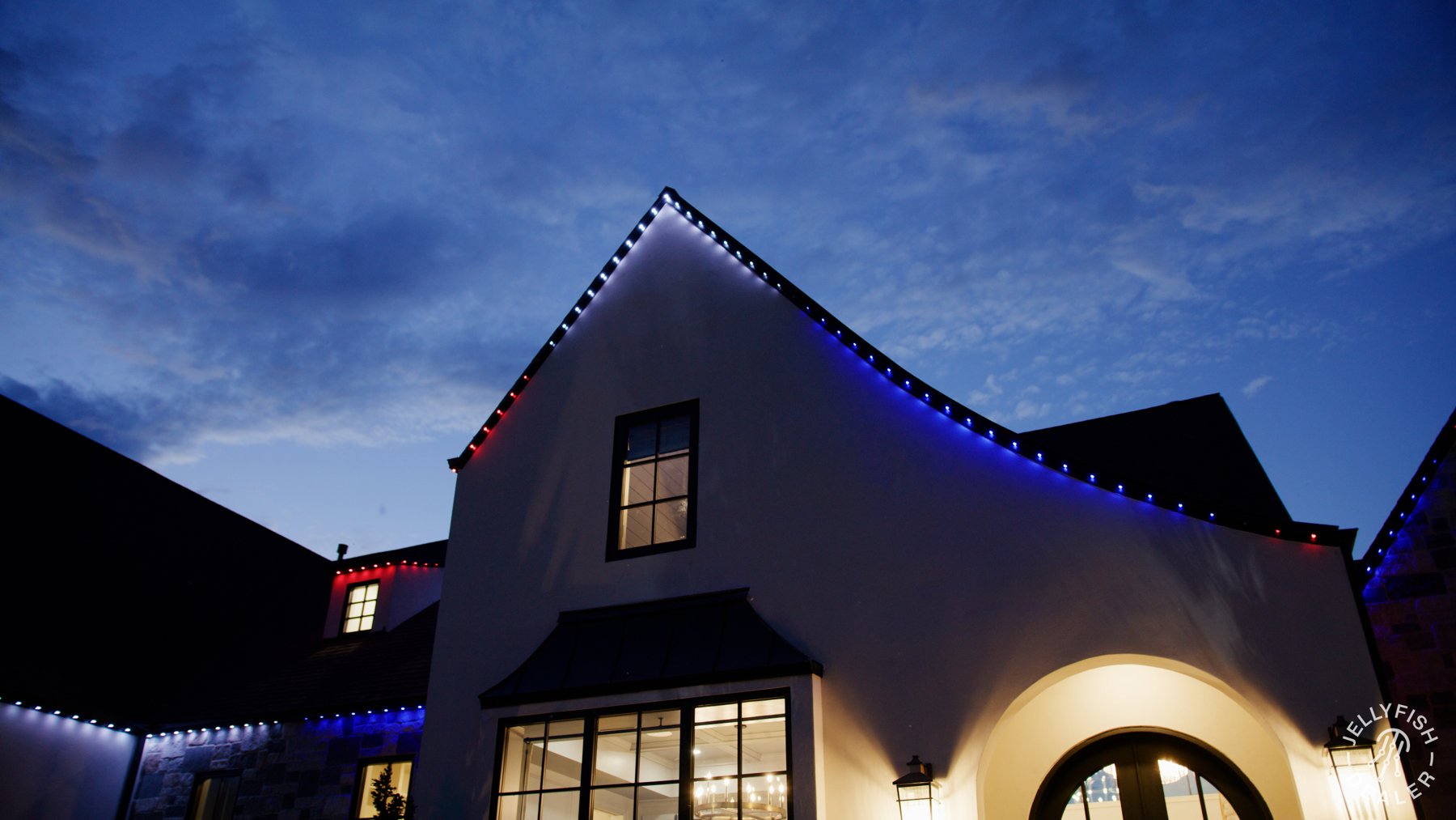Blue, white and red lights outlining a steep roof peak.