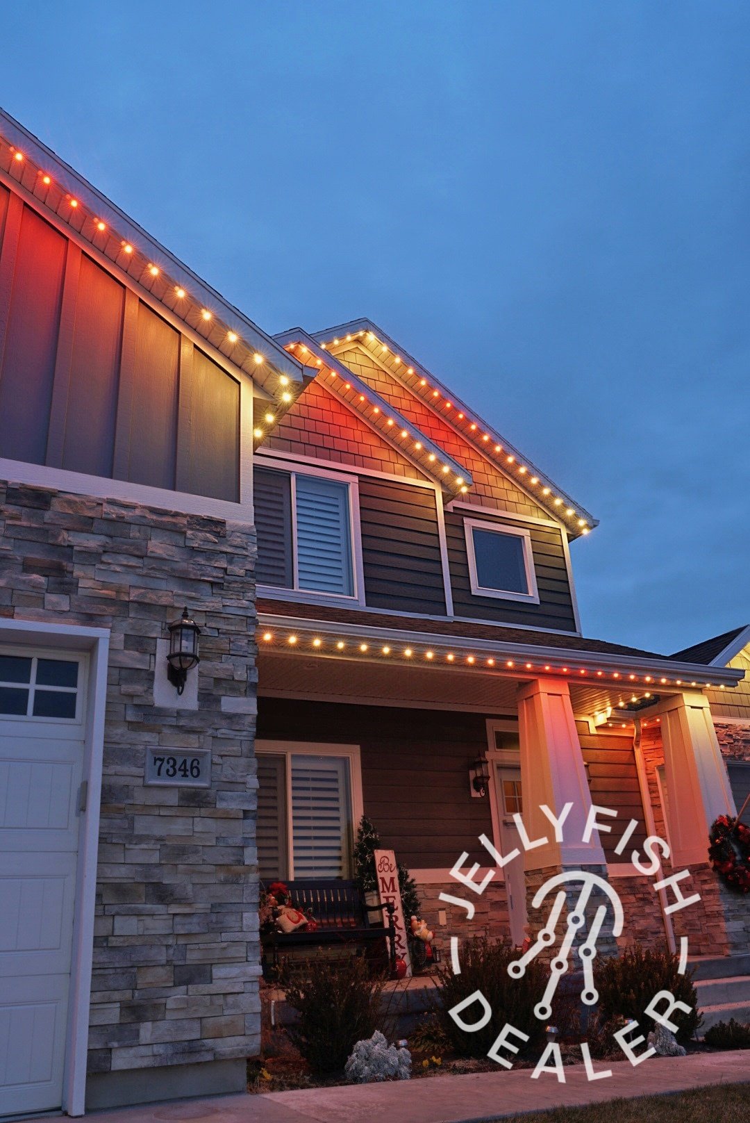 Red and gold lights along a home’s upper roofline.