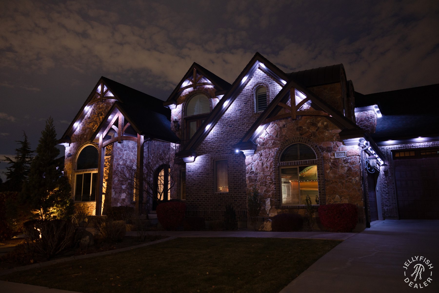 Selected white lights highlighting stone gables and architectural details.