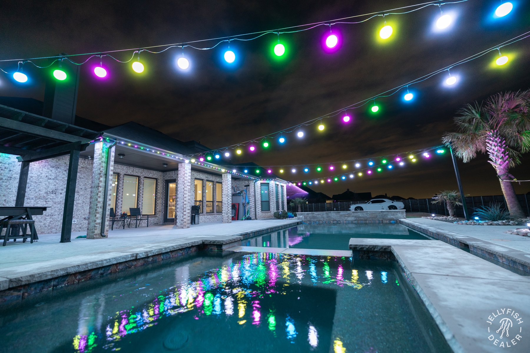 Color-changing patio bulbs above a swimming pool.