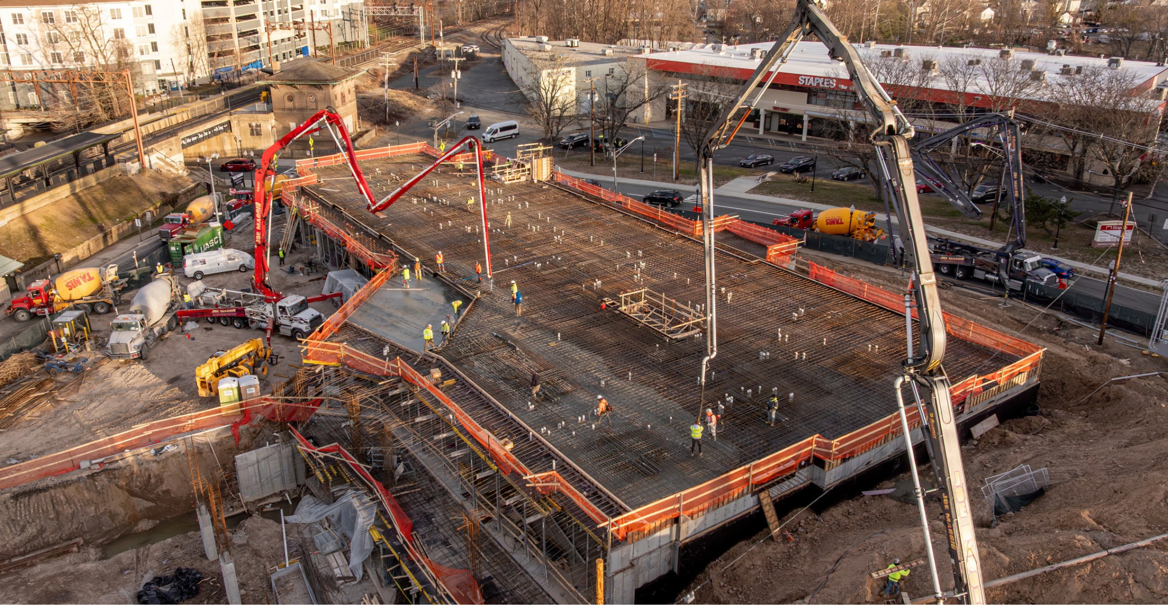 Two Joe Maggio Construction concrete pump trucks pouring a transfer slab on a large-scale commercial project in Morristown, New Jersey.