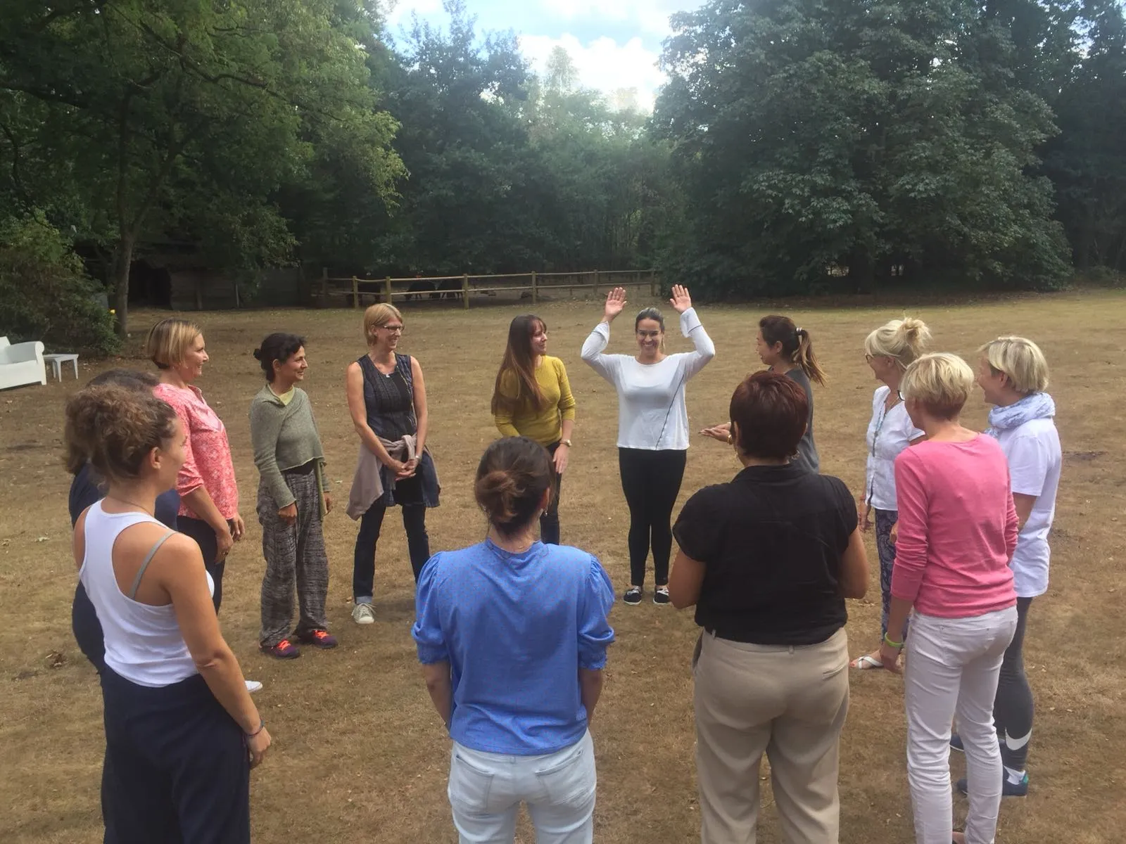 A group of trainees standing in a circle outdoors during an AMT training day