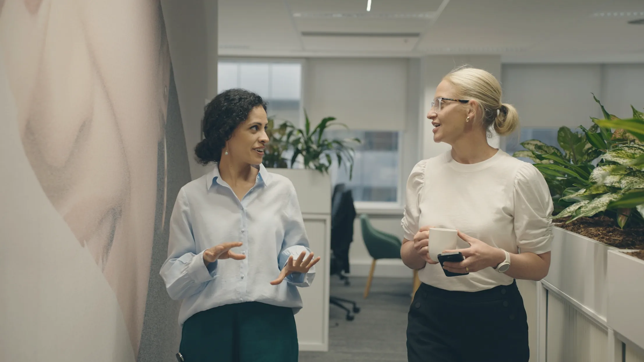 Two Revlon colleagues talking in the office corridor