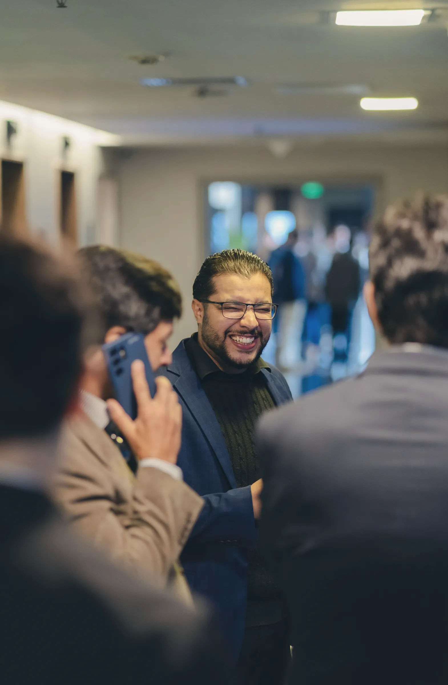 Man laughing with colleagues at a networking event