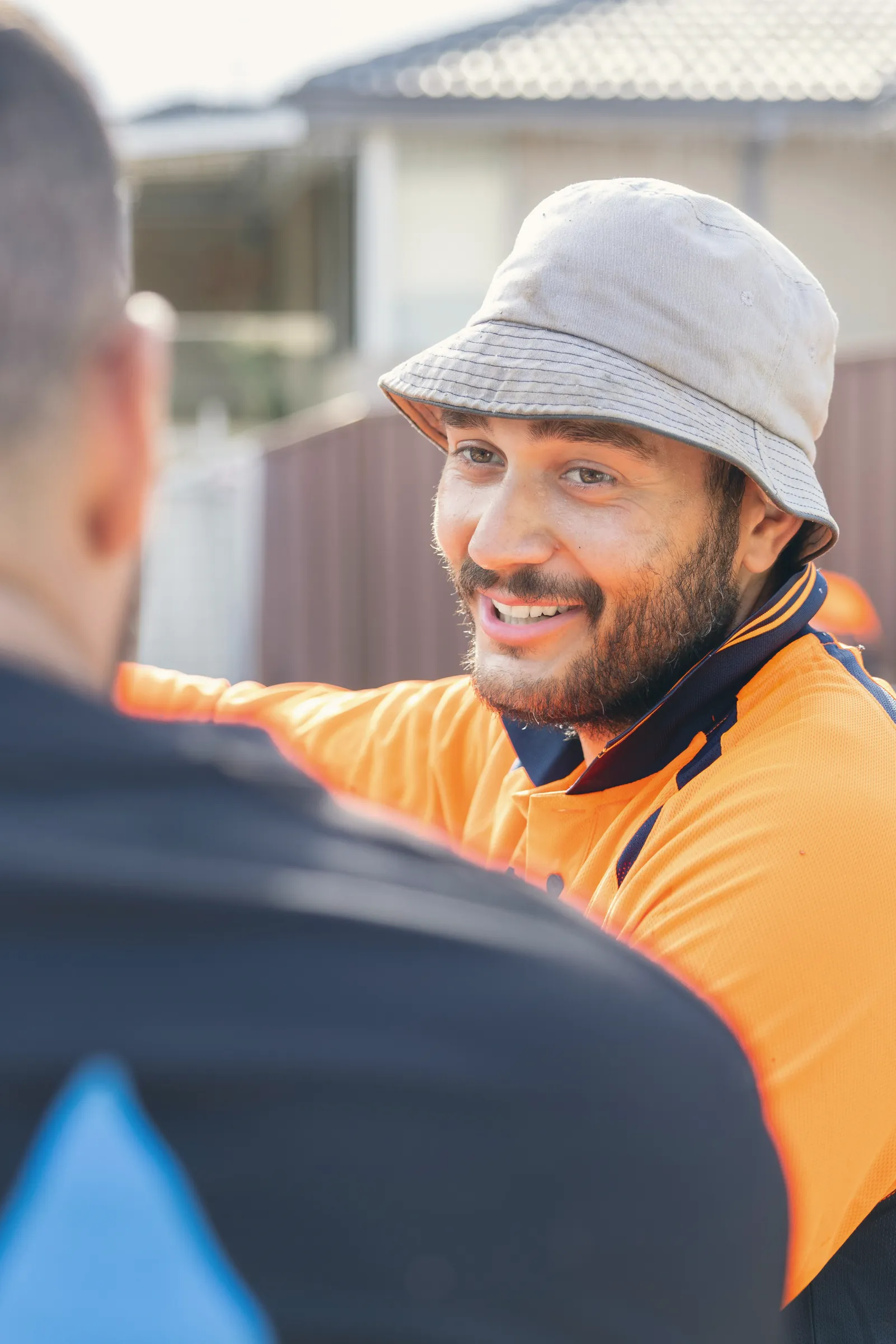 Tradesperson in hi-vis chatting with a colleague on site