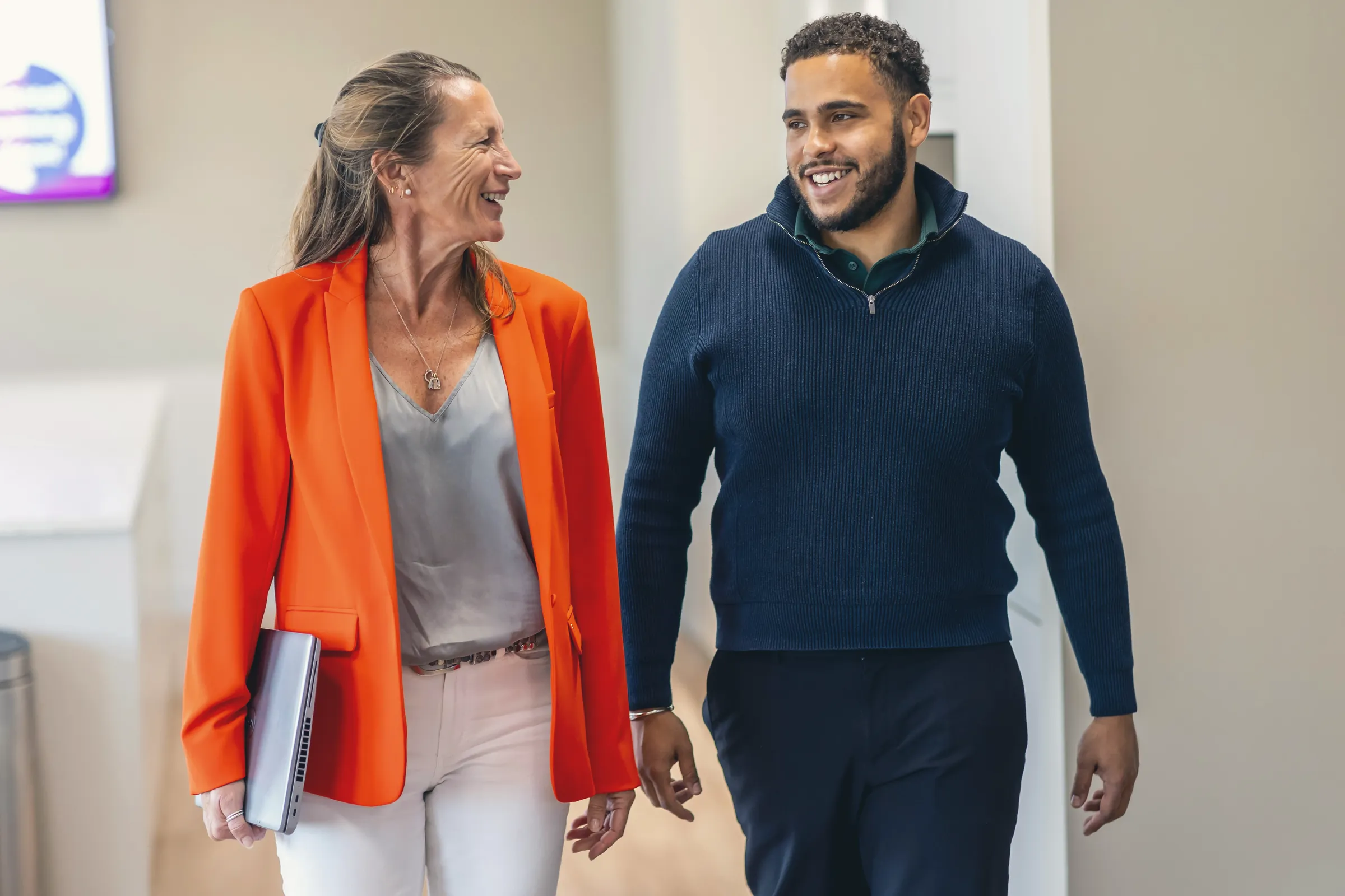 Two colleagues walking and talking in the office