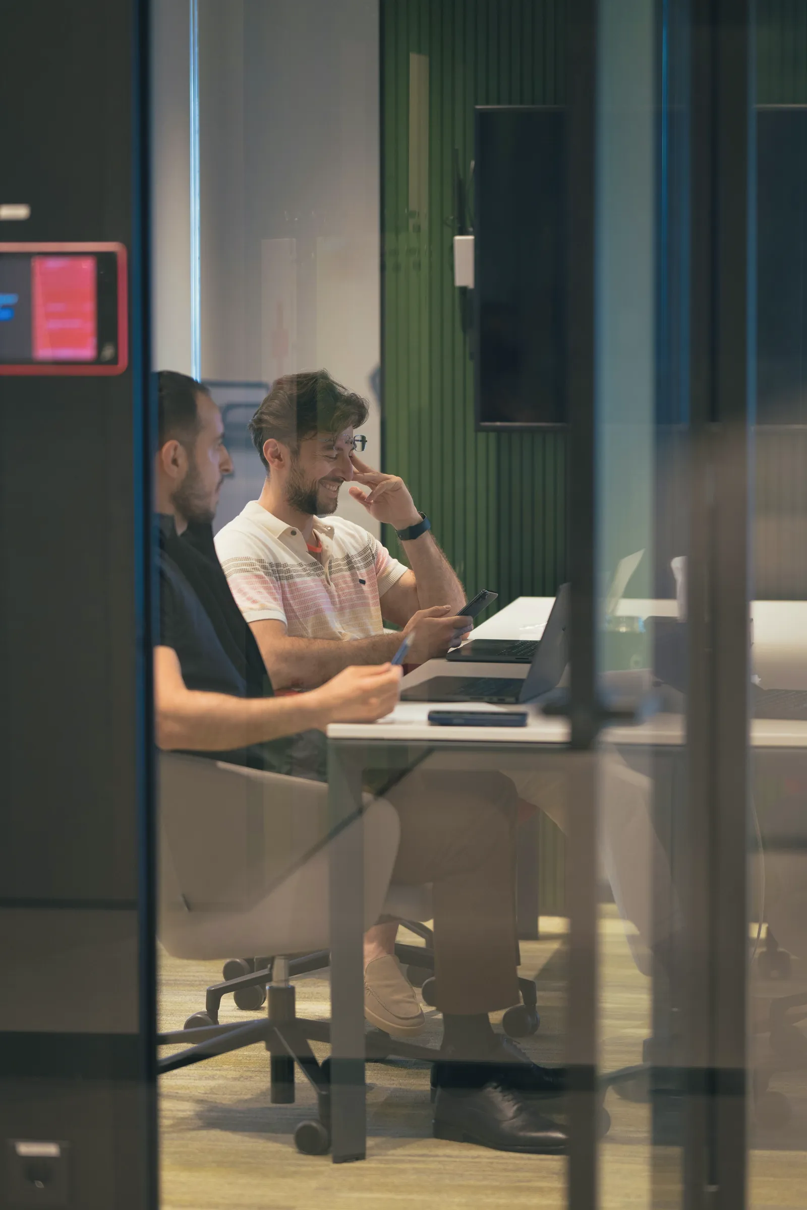Colleagues in a meeting room seen through glass