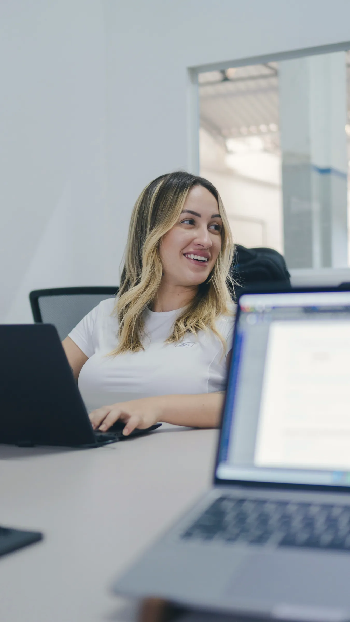 Woman smiling at a meeting table with colleagues