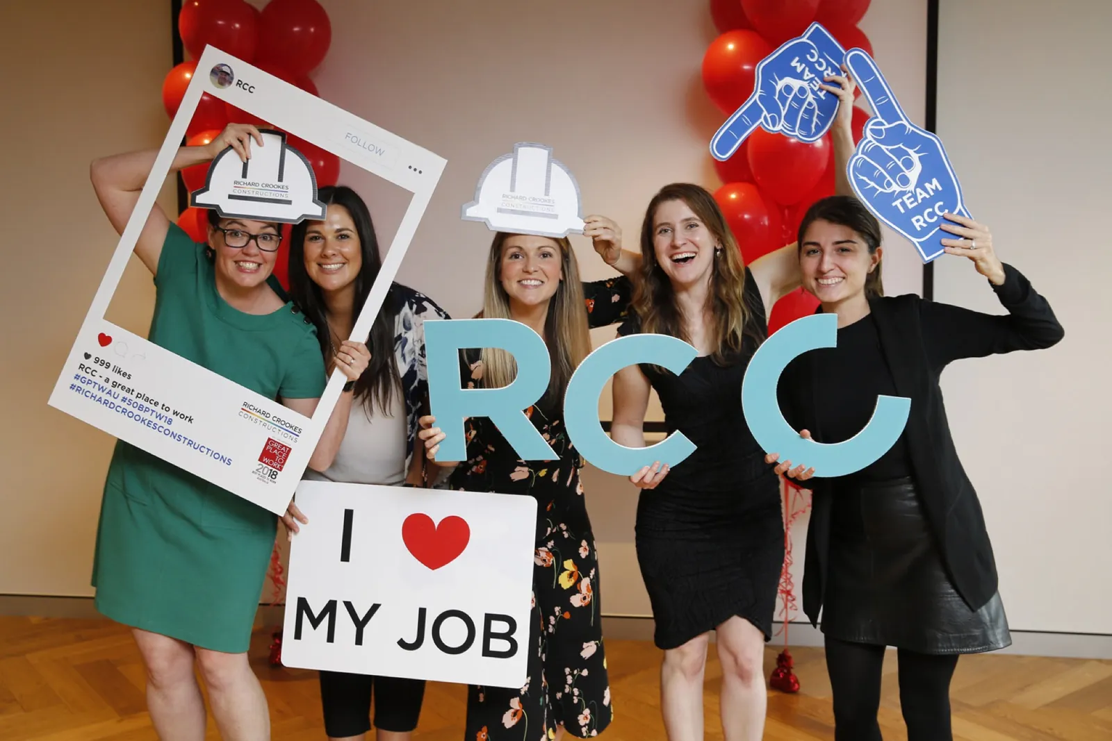 Richard Crookes team celebrating with hard hats and an I love my job sign