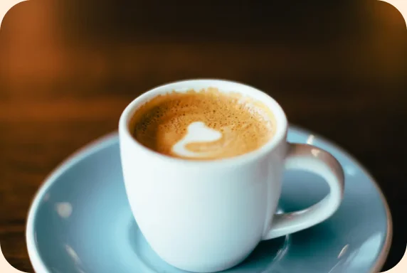 Kopje koffie met latte art op een schoteltje