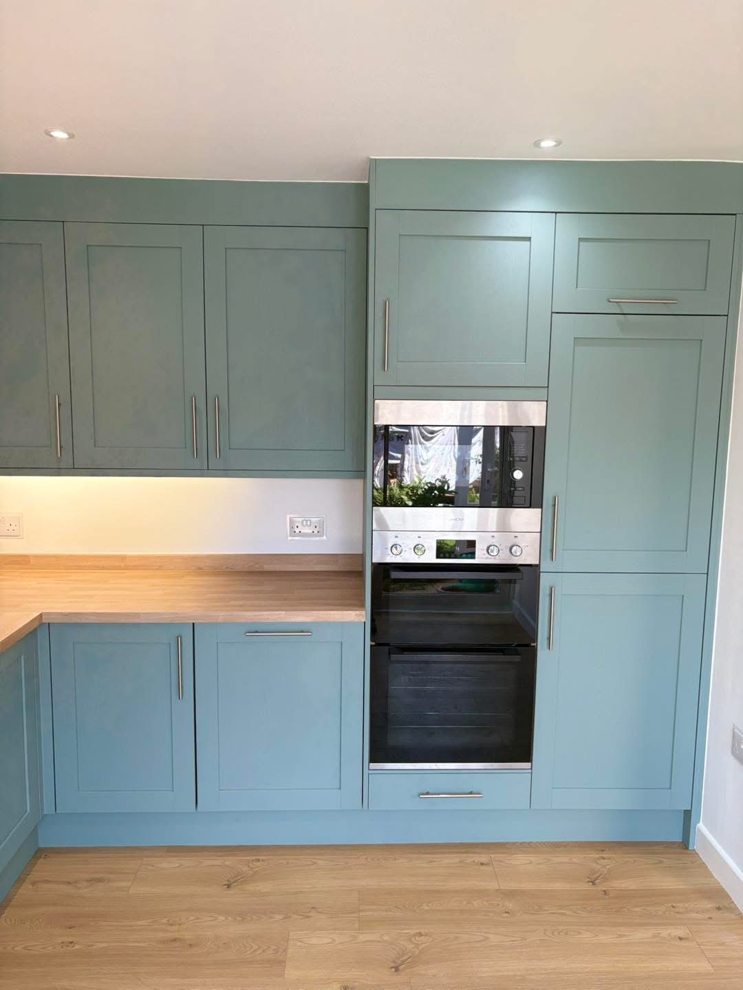 Built-in ovens and tall blue cabinets