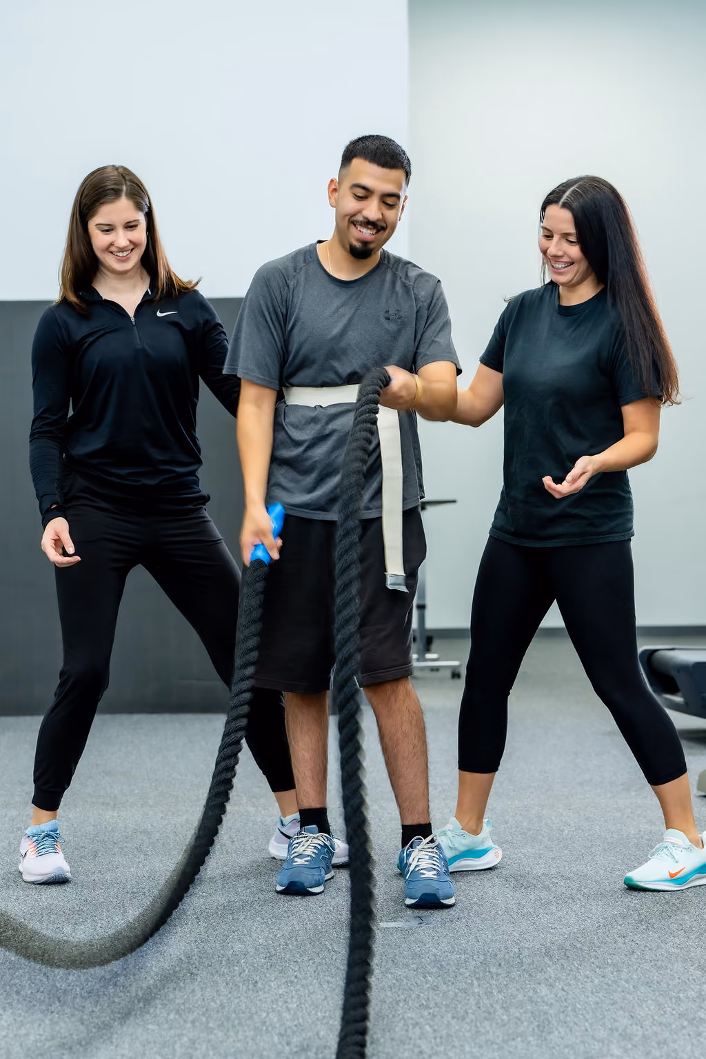 Two NeuroBridge clinicians coaching a patient through a battle-rope exercise