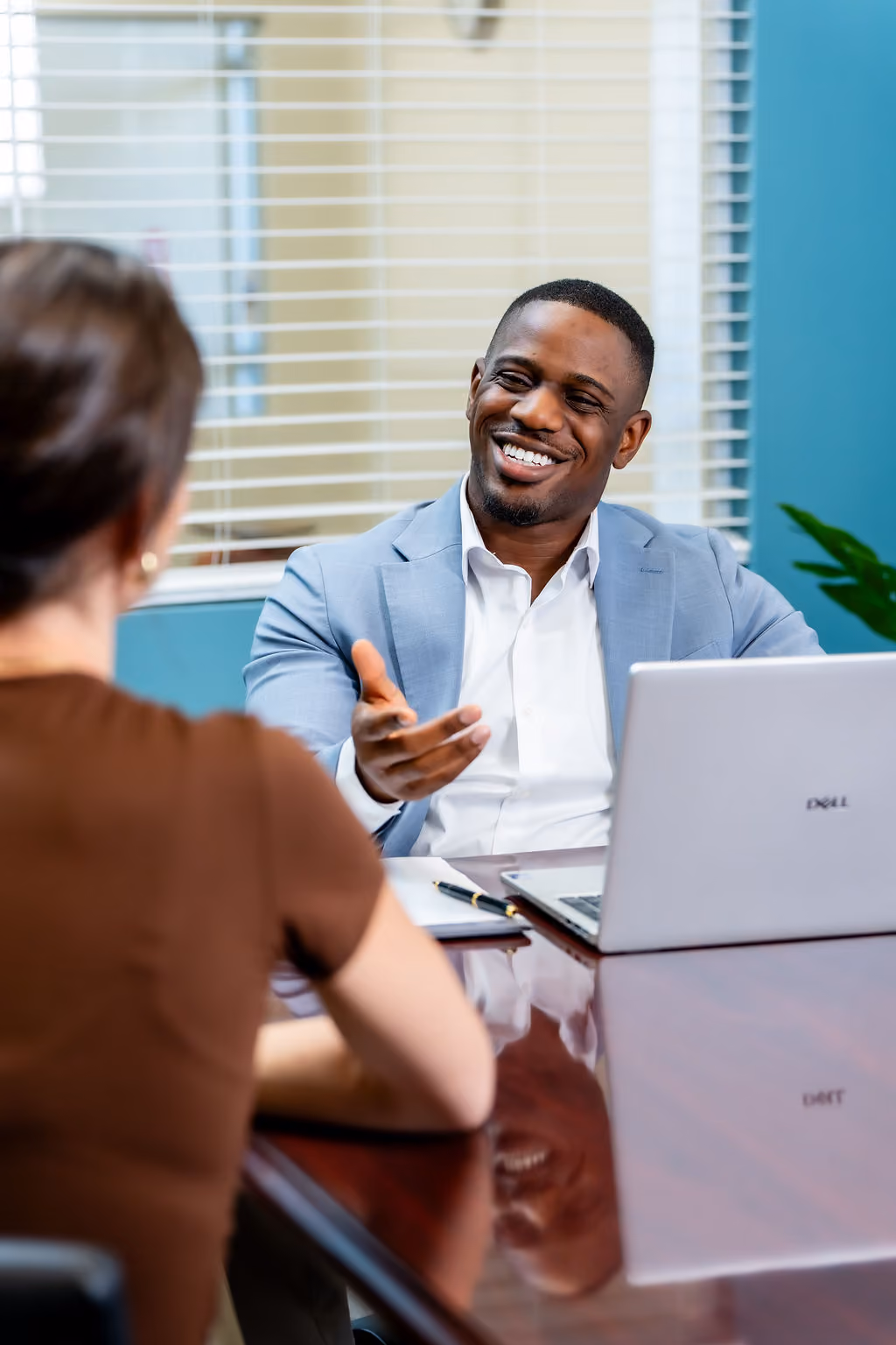 A NeuroBridge physician talking with a patient across a consultation table