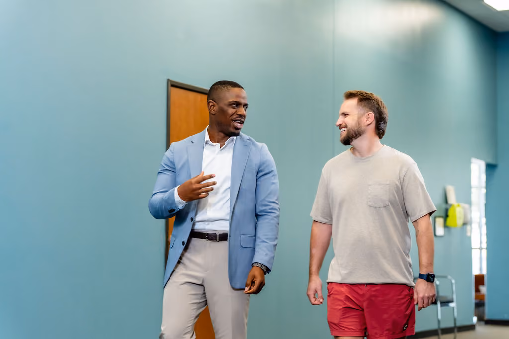 A NeuroBridge physician walking and talking with a patient in the clinic