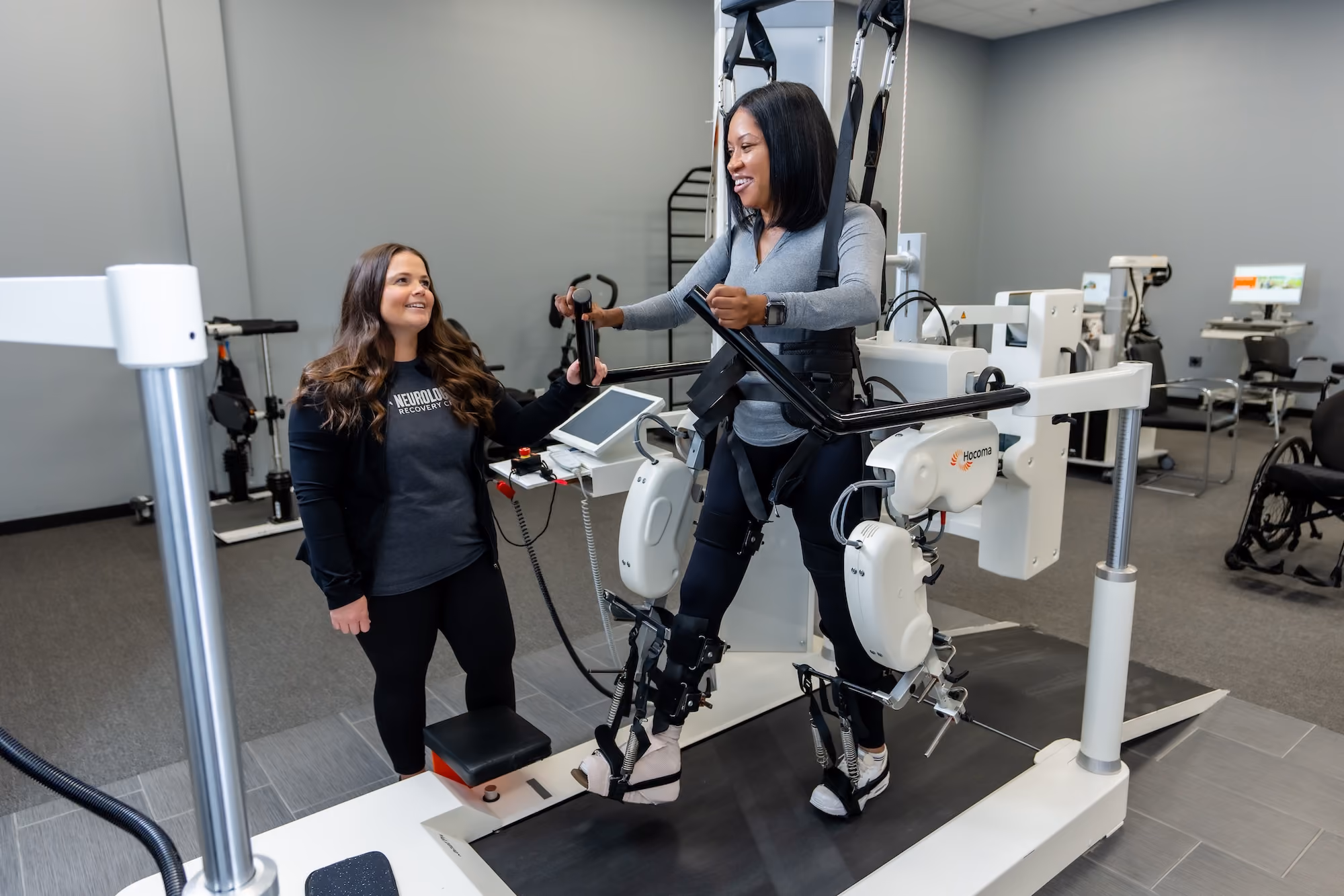 A NeuroBridge therapist guiding a patient through a session on a robotic gait trainer